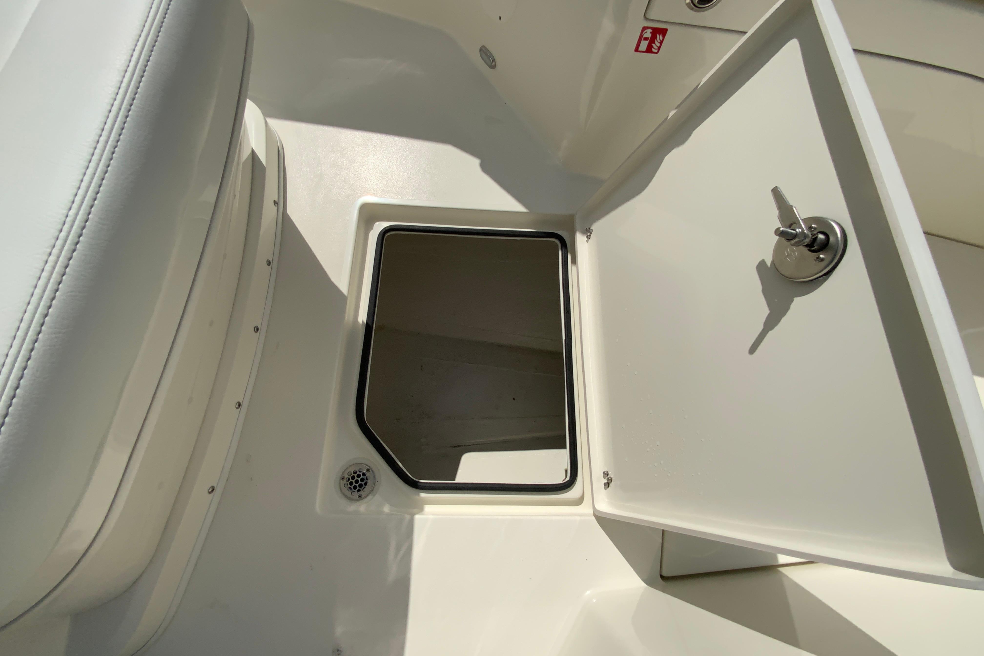 2027 Cobia 320 Center Console storage compartment with open hatch and secure lock.