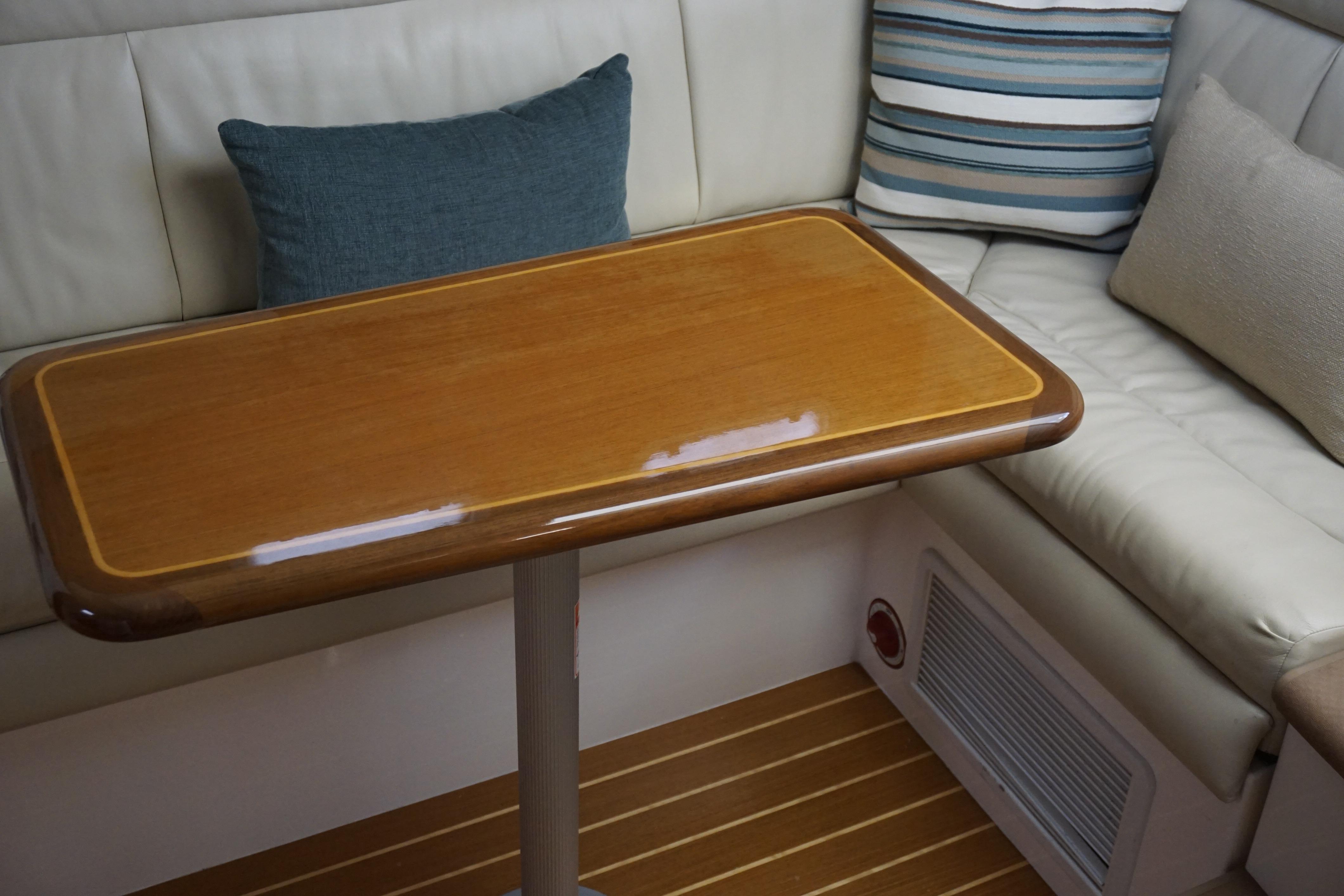 Interior of 2005 Cabo 35 Express yacht with wooden table and cushioned seating.