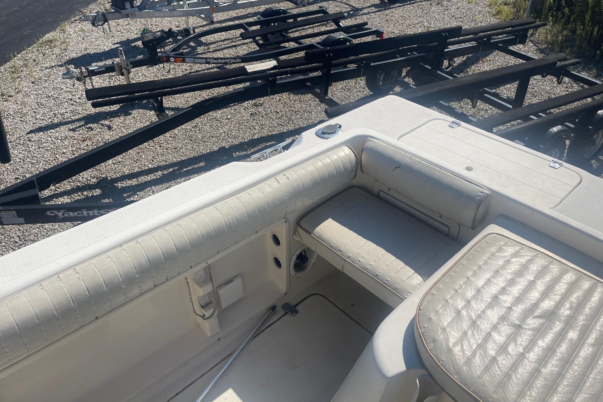 2000 Seamaster 2388 WA boat interior with white seating and nearby trailers.