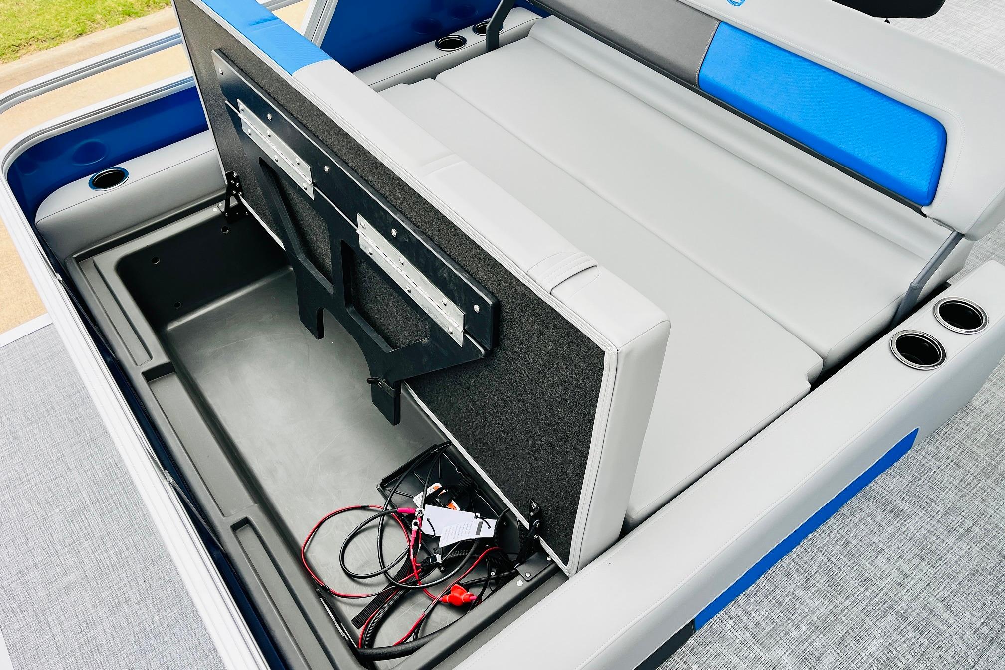 2026 Sun Tracker Party Barge 22 RF DLX storage compartment with seating and cup holders.