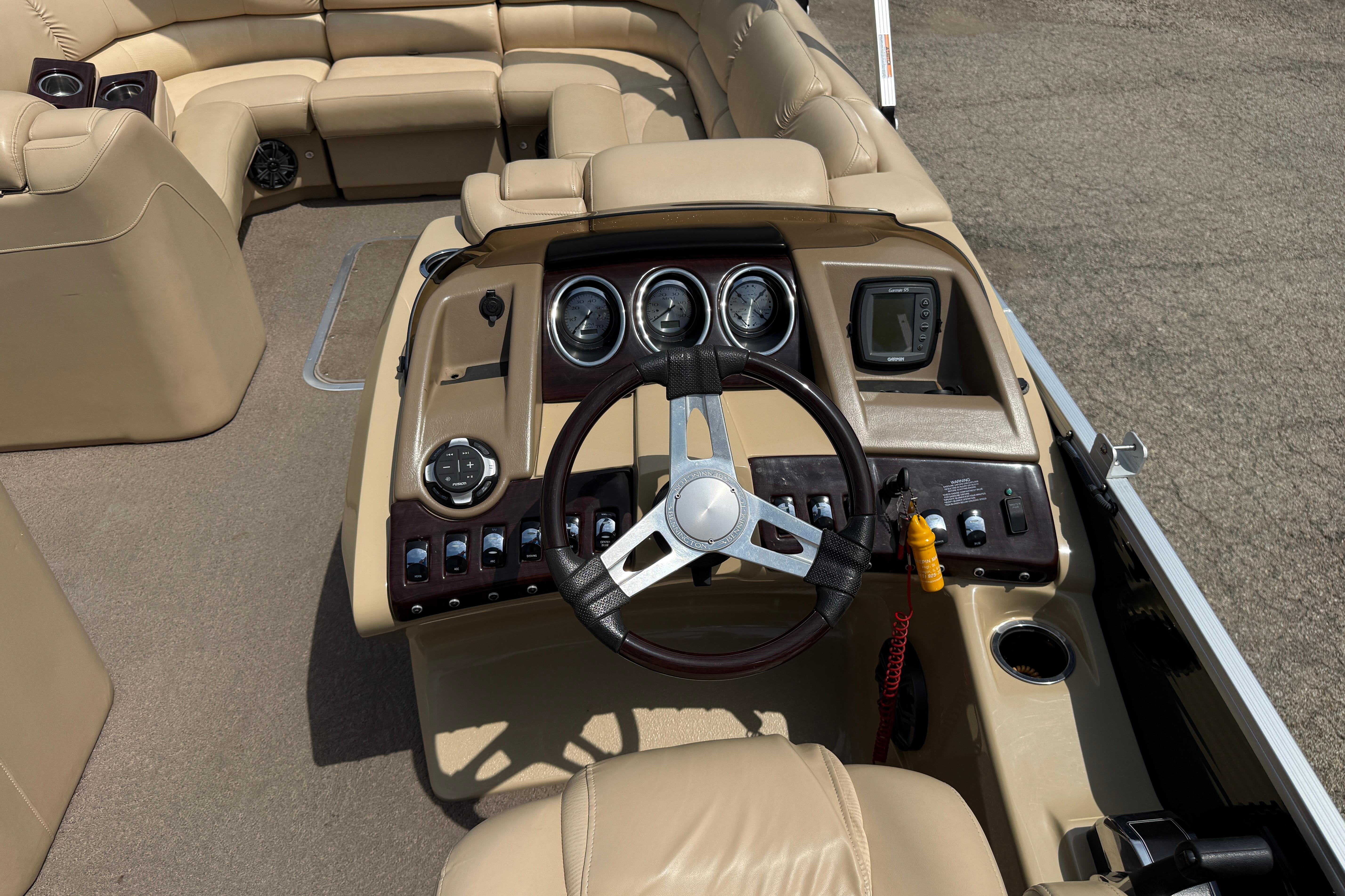 Steering console of a 2011 Bennington 2575QCW I/O boat with beige seating.