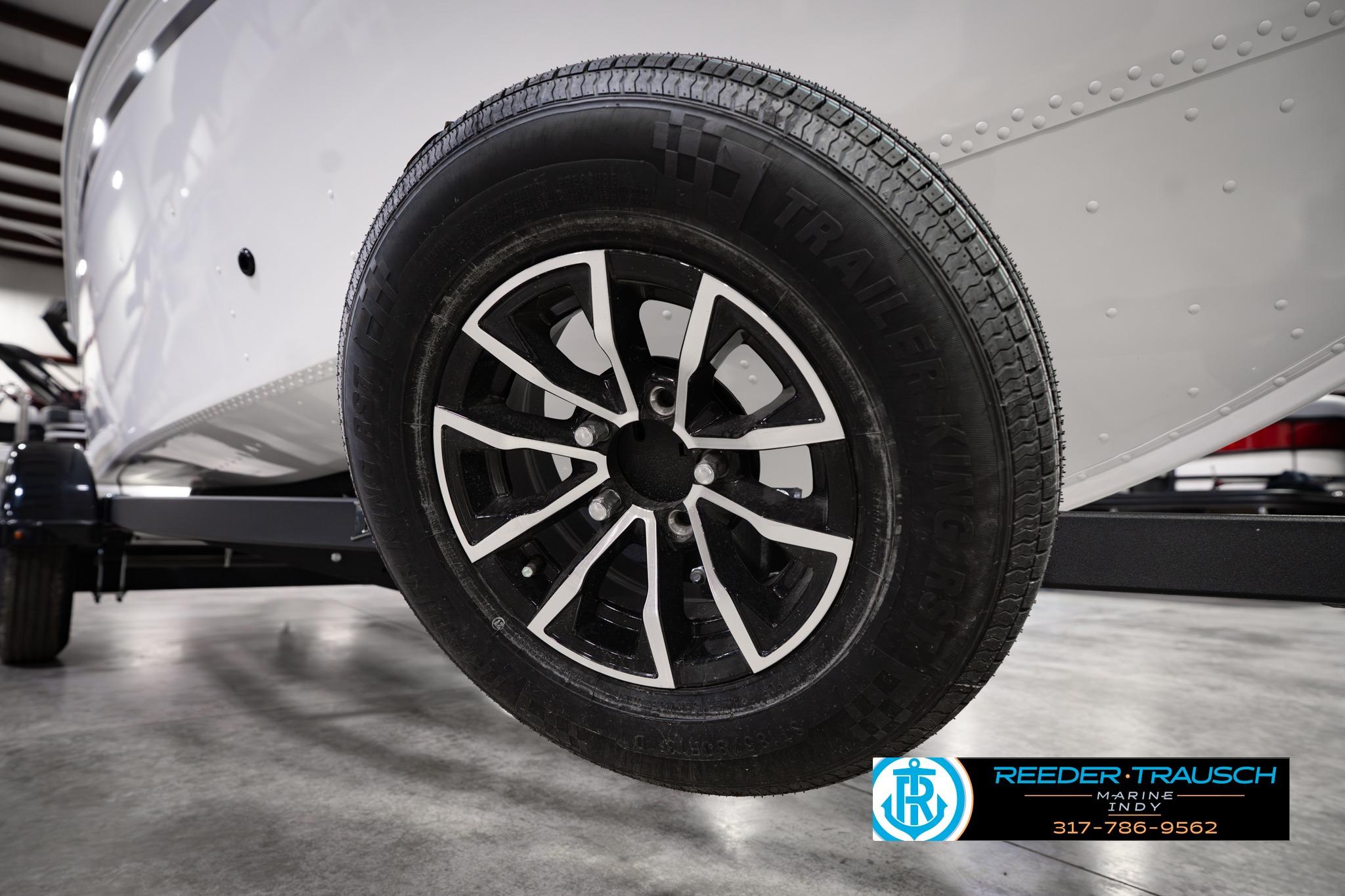 2026 Lund 1650 Rebel XL SS trailer wheel in showroom, Reeder Trausch Marine logo visible.
