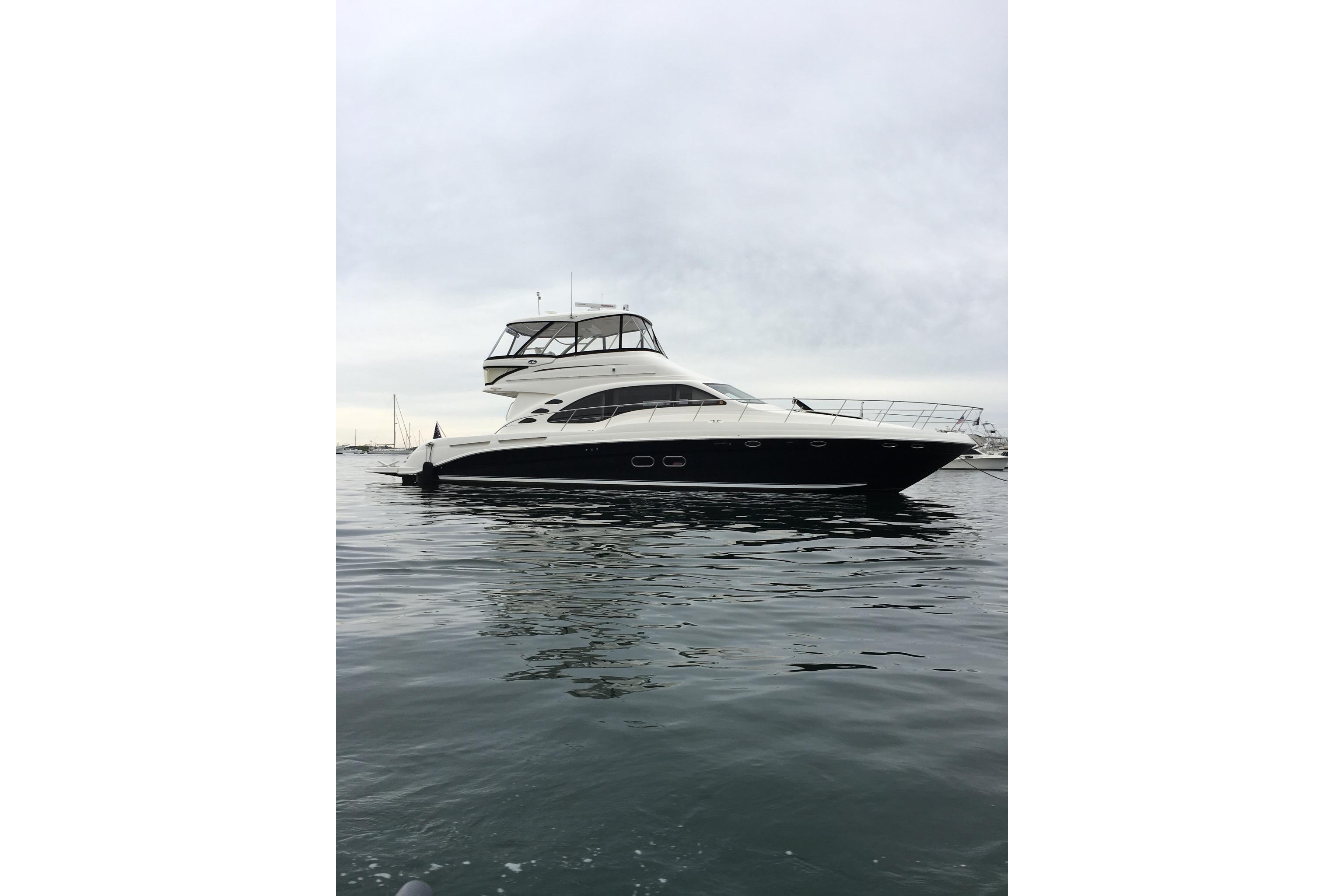 2007 Sea Ray 580 Sedan Bridge yacht on calm water under cloudy sky.