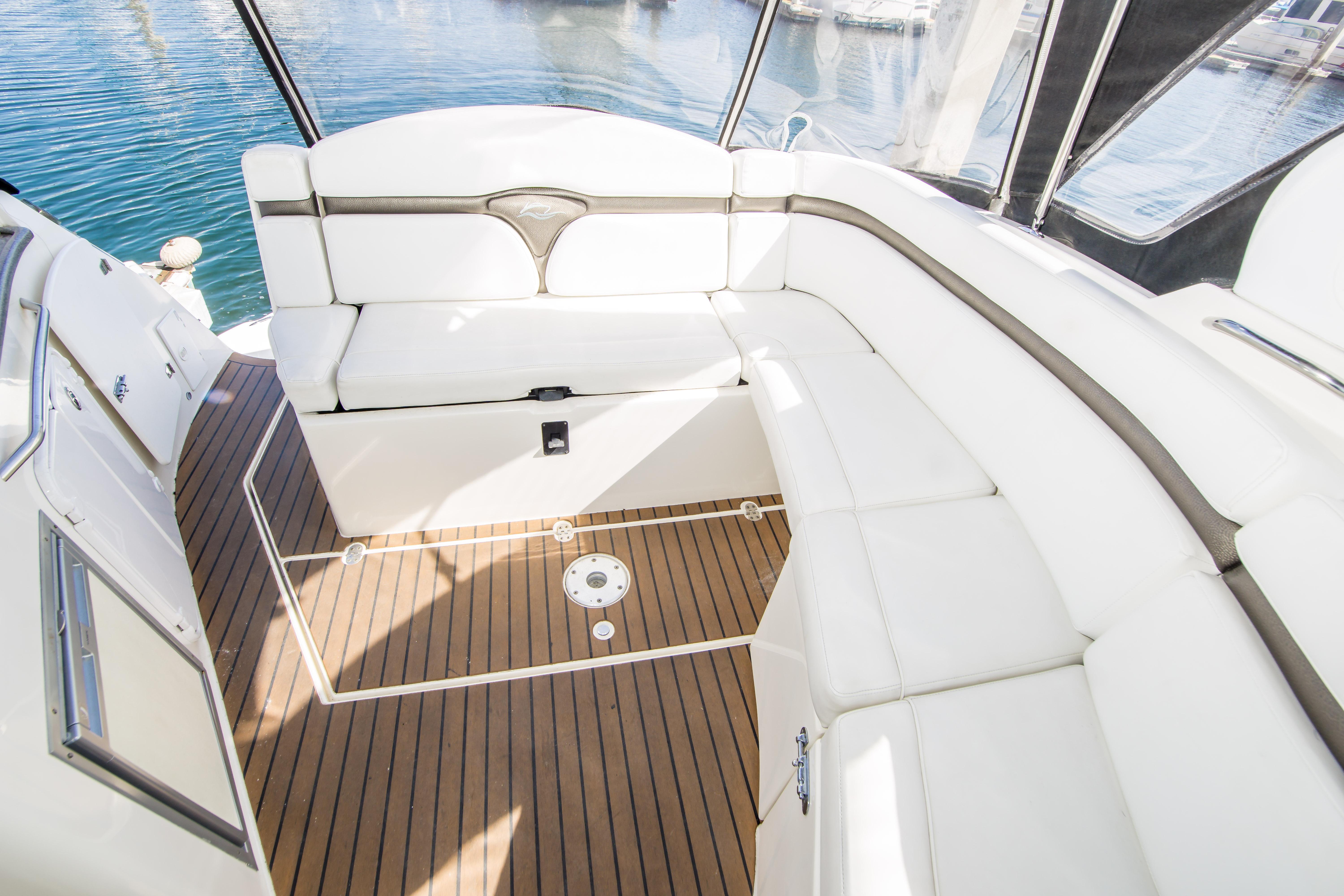 2012 Rinker 310 Express Cruiser interior with white seating and teak flooring.