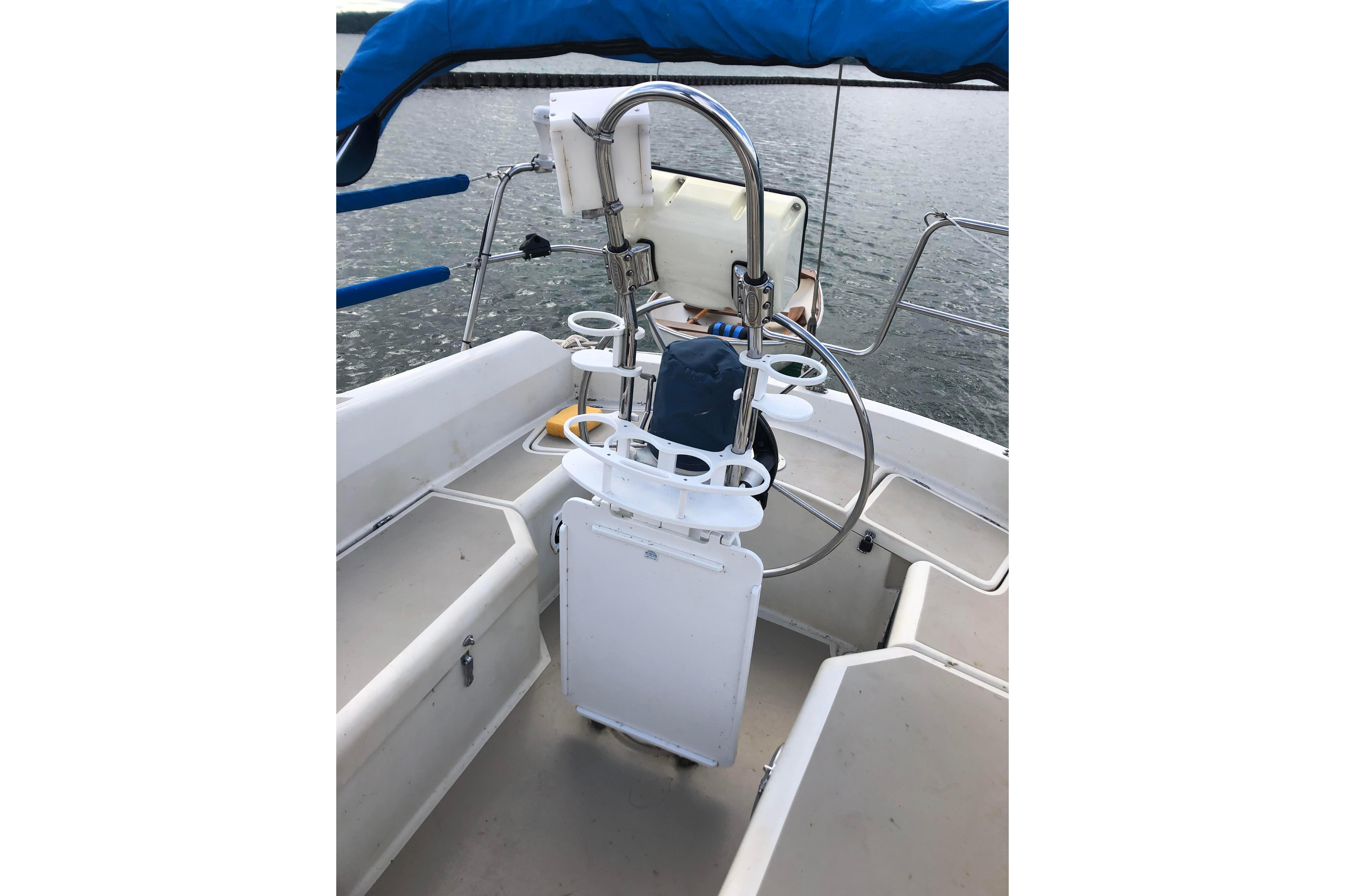 1983 O'Day 34 sailboat cockpit with steering wheel and seating, on calm water.