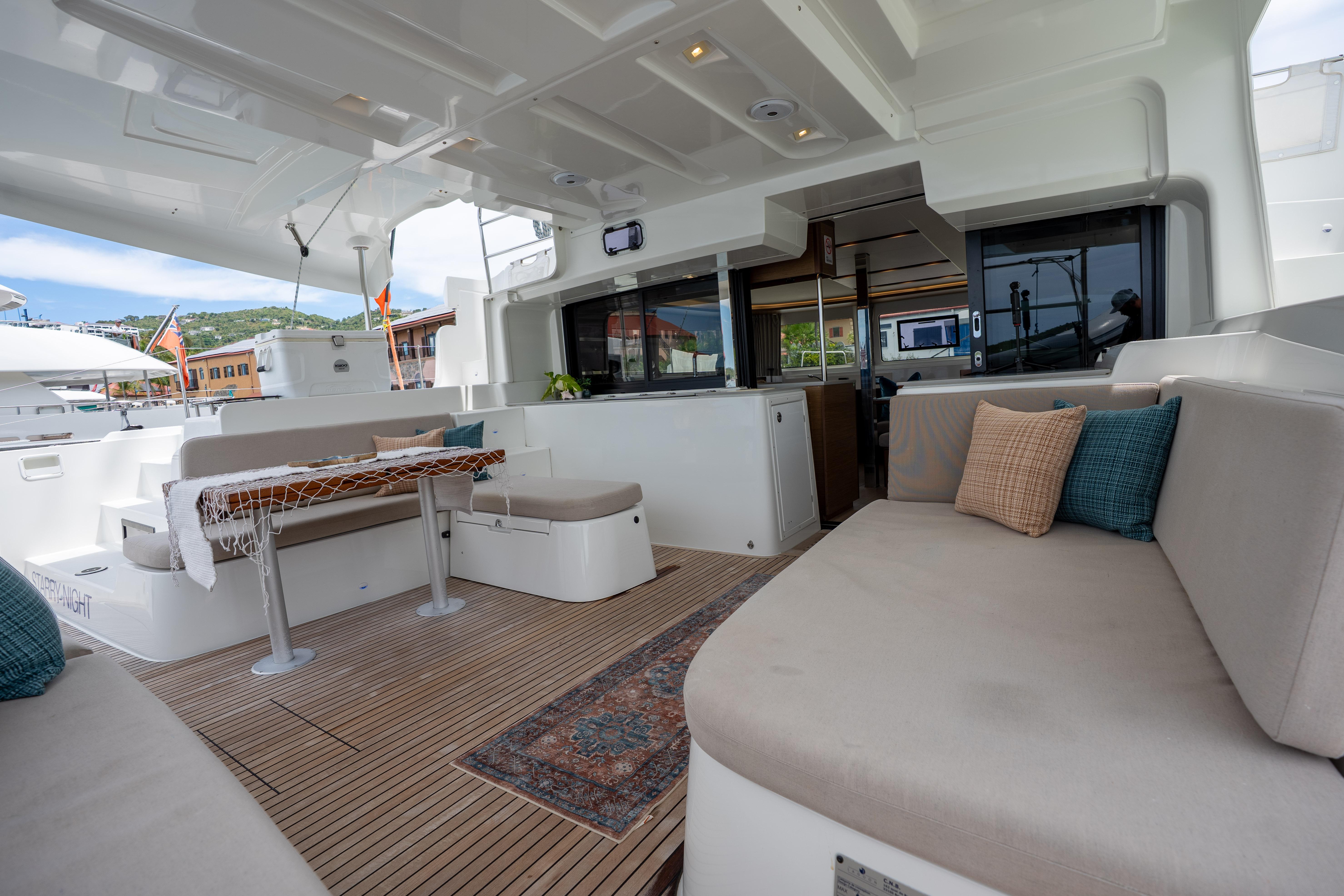 Spacious deck of 2022 Lagoon 46 catamaran with comfortable seating and elegant decor.
