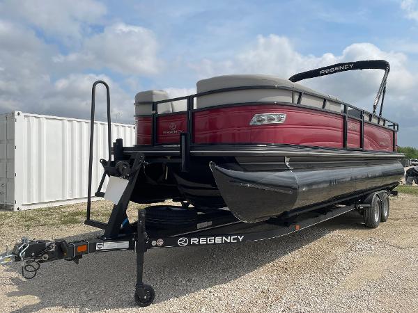 2023 Regency 250DL3 pontoon boat on trailer, red and black design, parked outdoors.