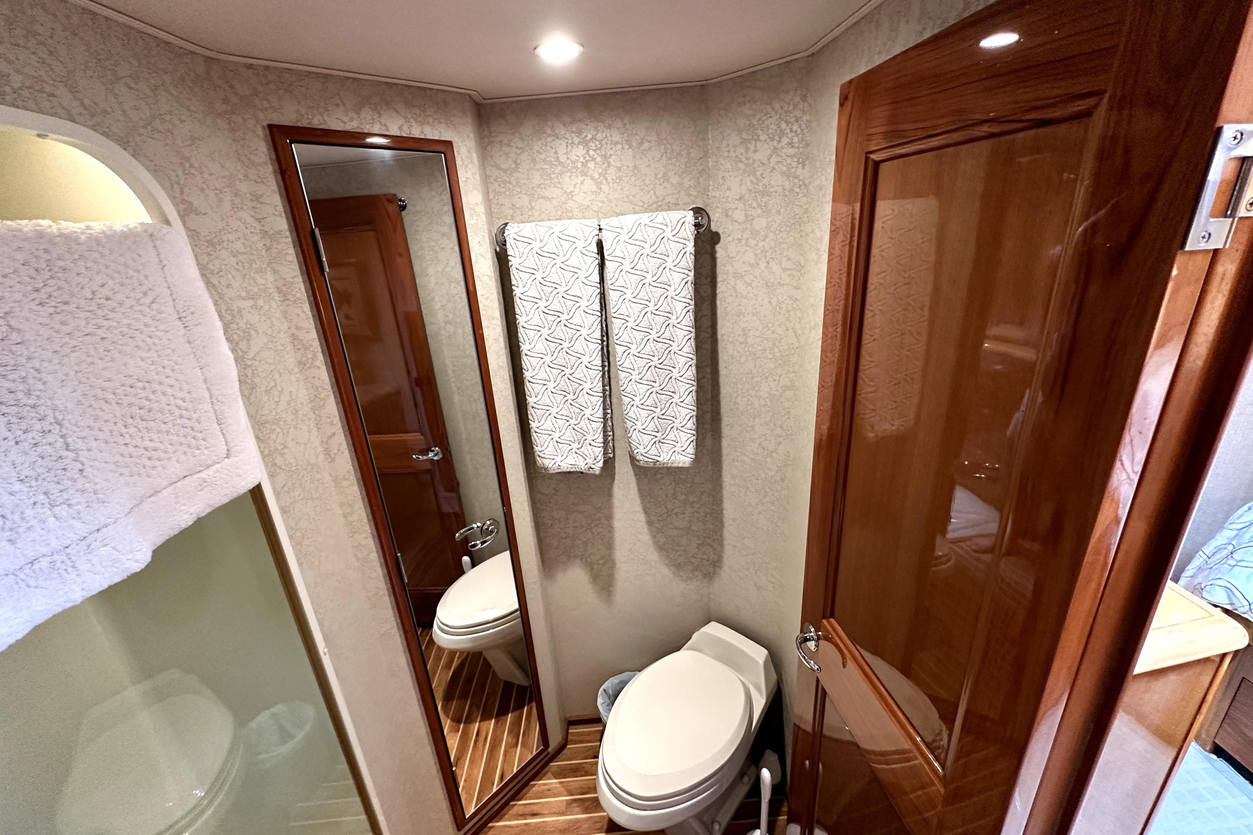 Bathroom interior of 2003 Viking 61 Convertible yacht with wooden accents and modern fixtures.