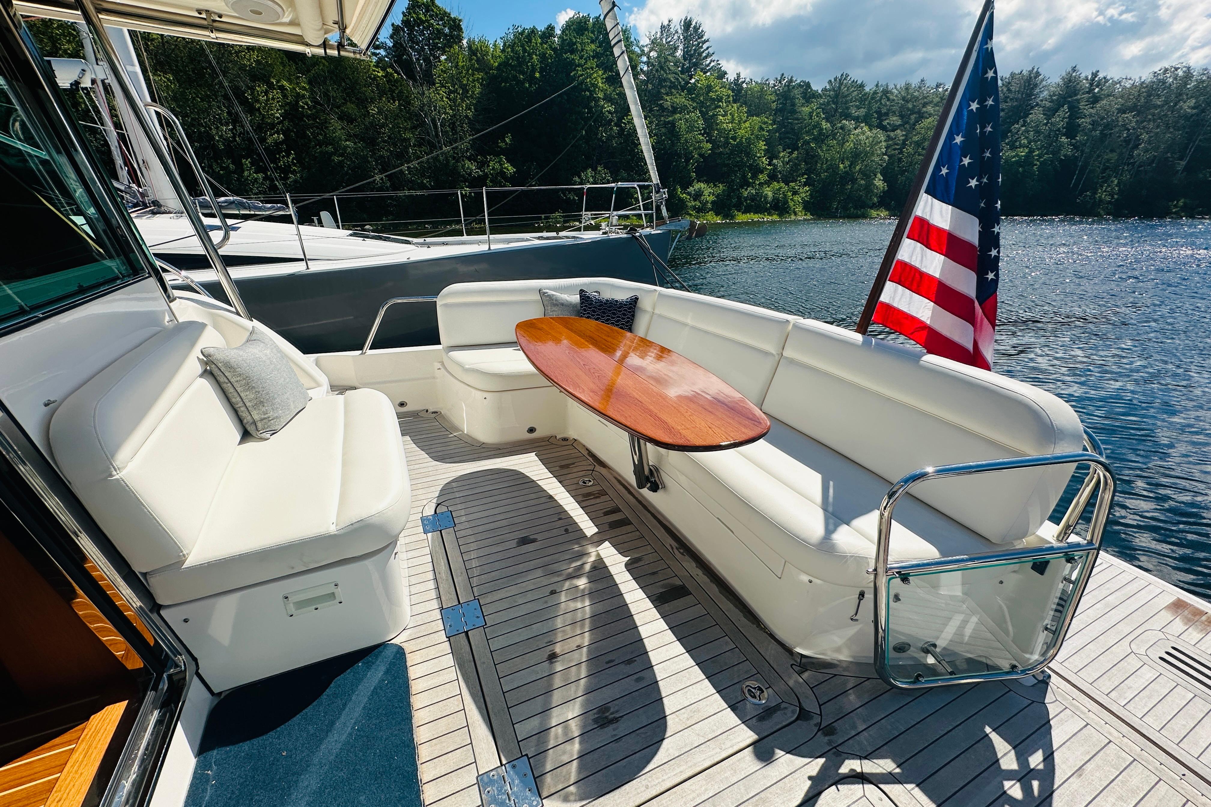 Luxurious 2025 Sabre 48 Salon Express yacht deck with seating and American flag.
