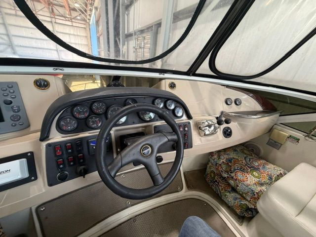 The cockpit of a 2005 Carver 44 Cockpit Motor Yacht with steering wheel, instruments, and seat cushions.