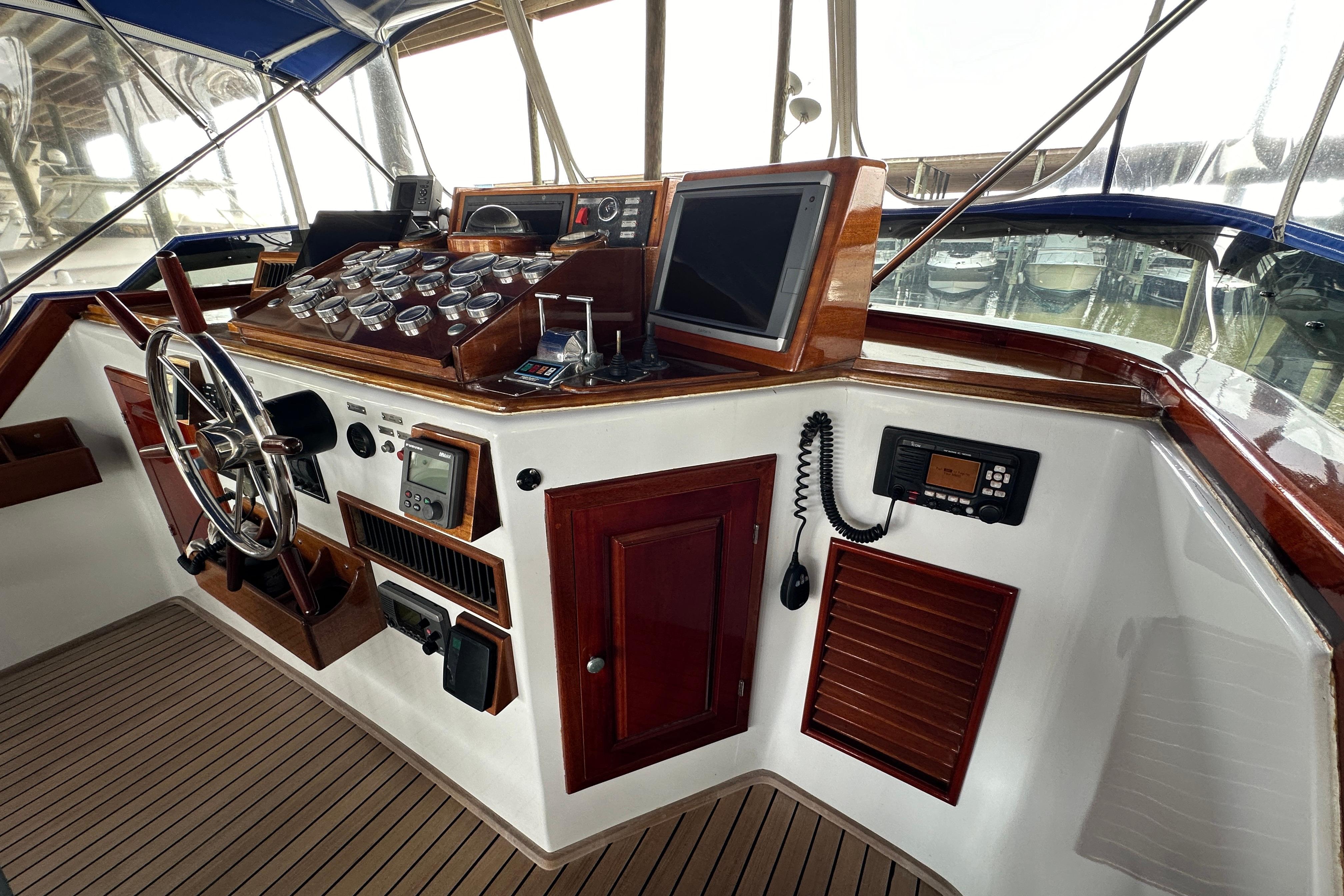 Cockpit of a 1980 Bertram 58 Convertible yacht with classic wooden dashboard and steering wheel.
