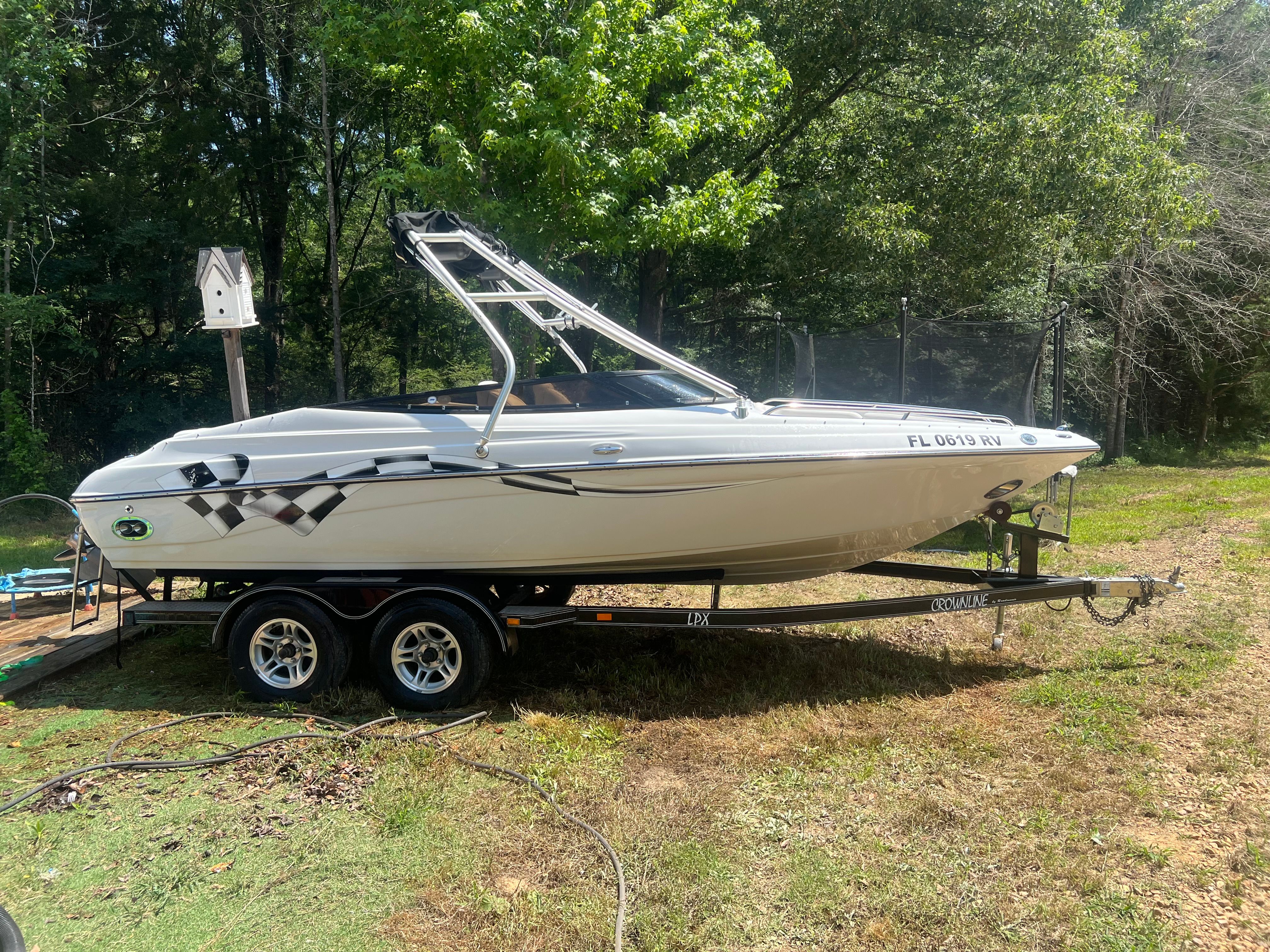 2001 Crownline 202 BR boat parked on trailer outdoors.