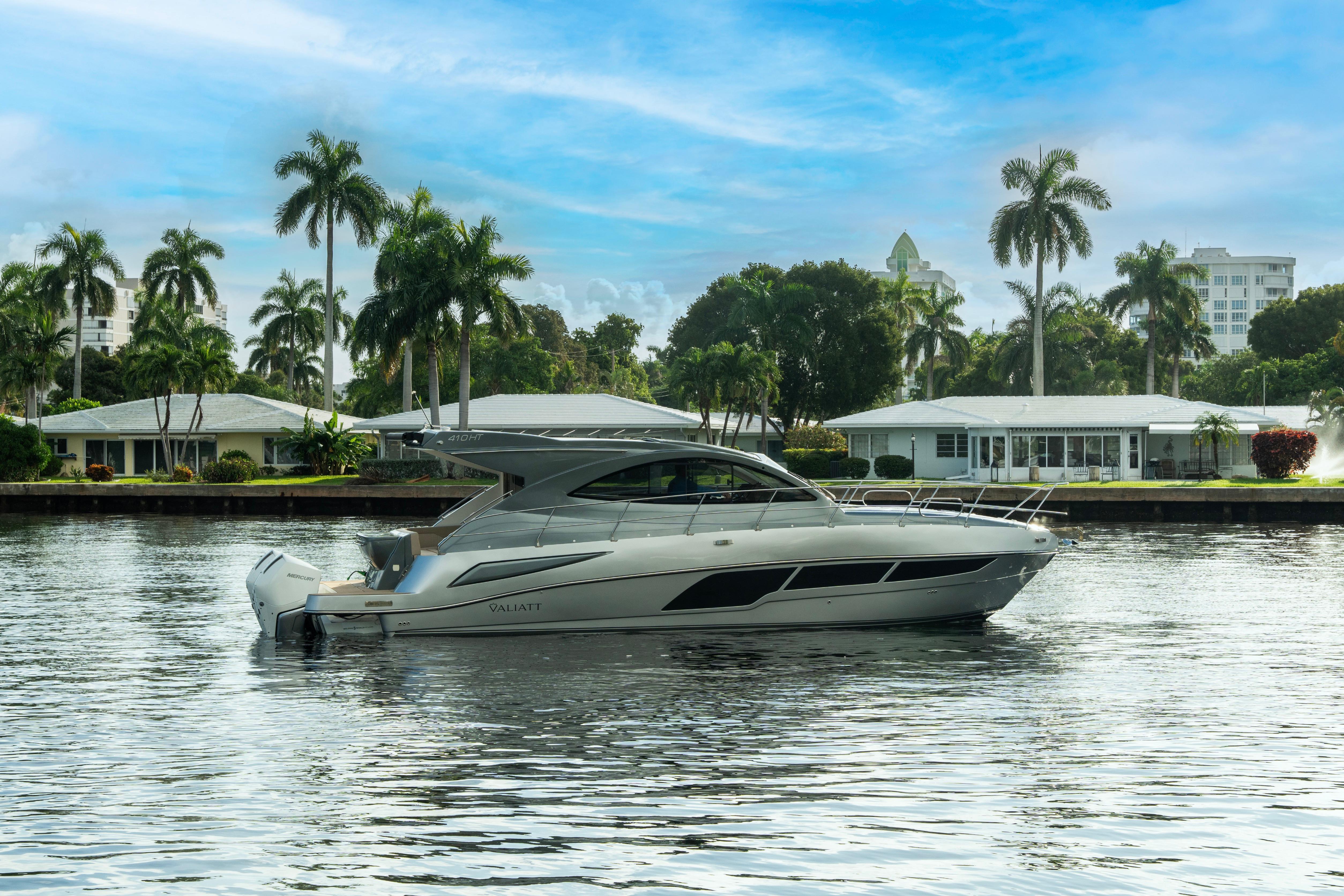 Luxury Valiatt 410HT yacht cruising on a serene waterway, surrounded by palm trees, 2025 model.