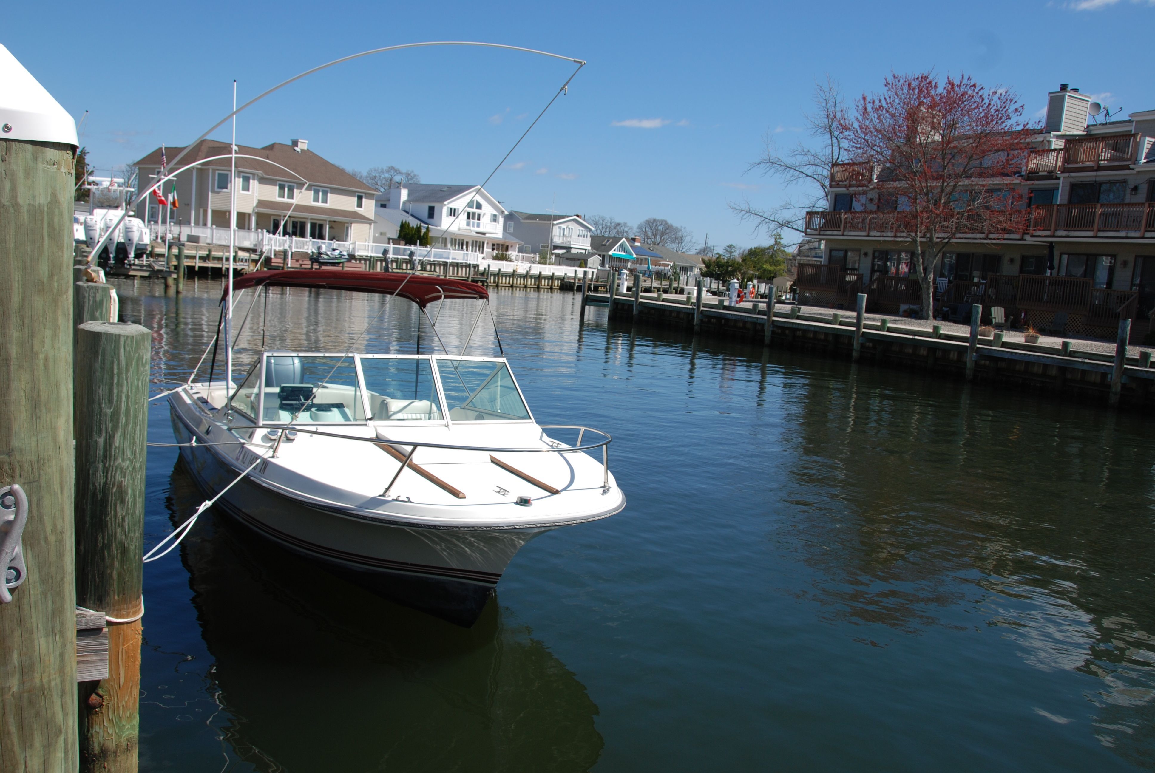 A 1987 Wellcraft V-20 Steplift docked in a calm residential area.