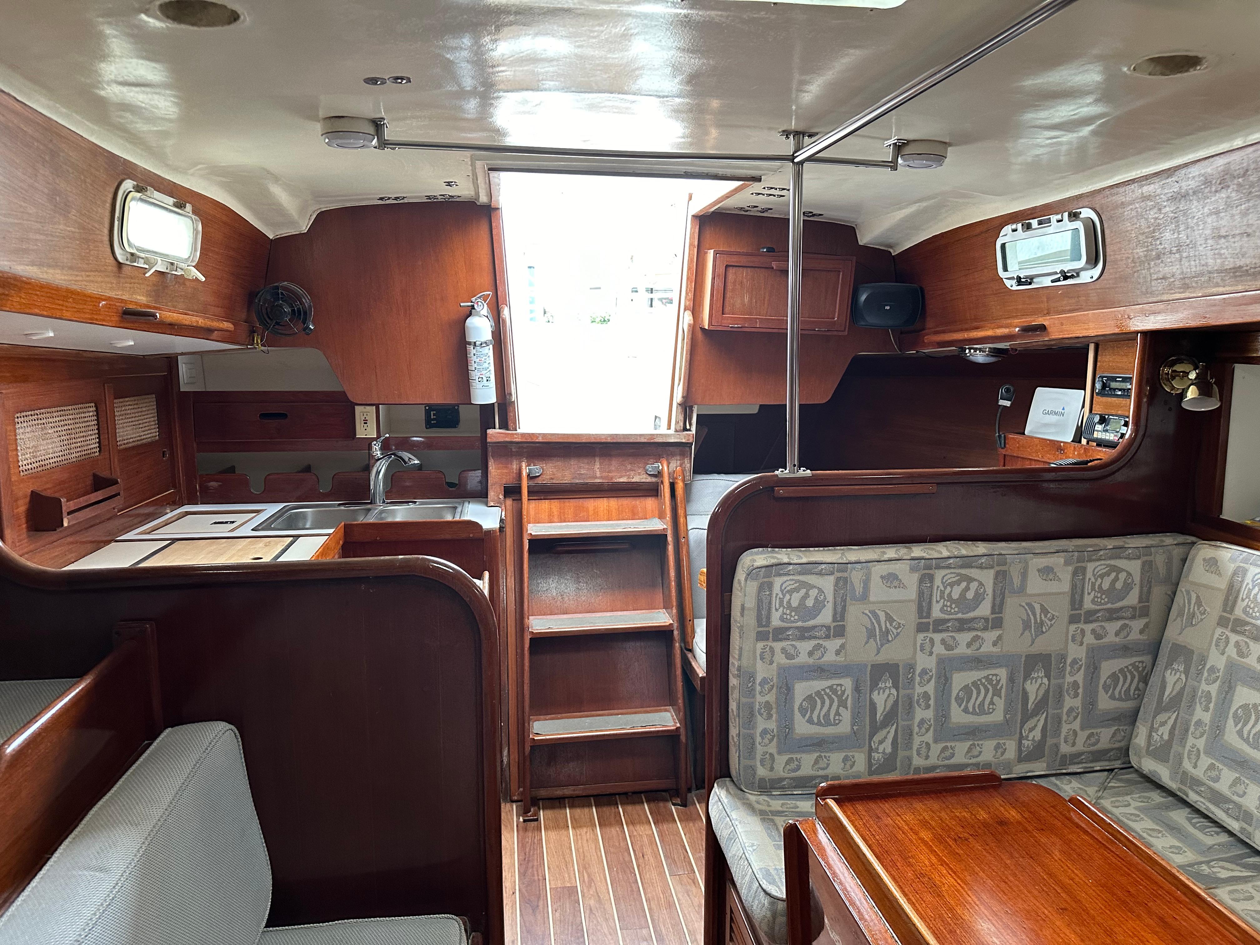 Interior of 1981 Tartan 37 sloop with wooden cabinetry and patterned seating.