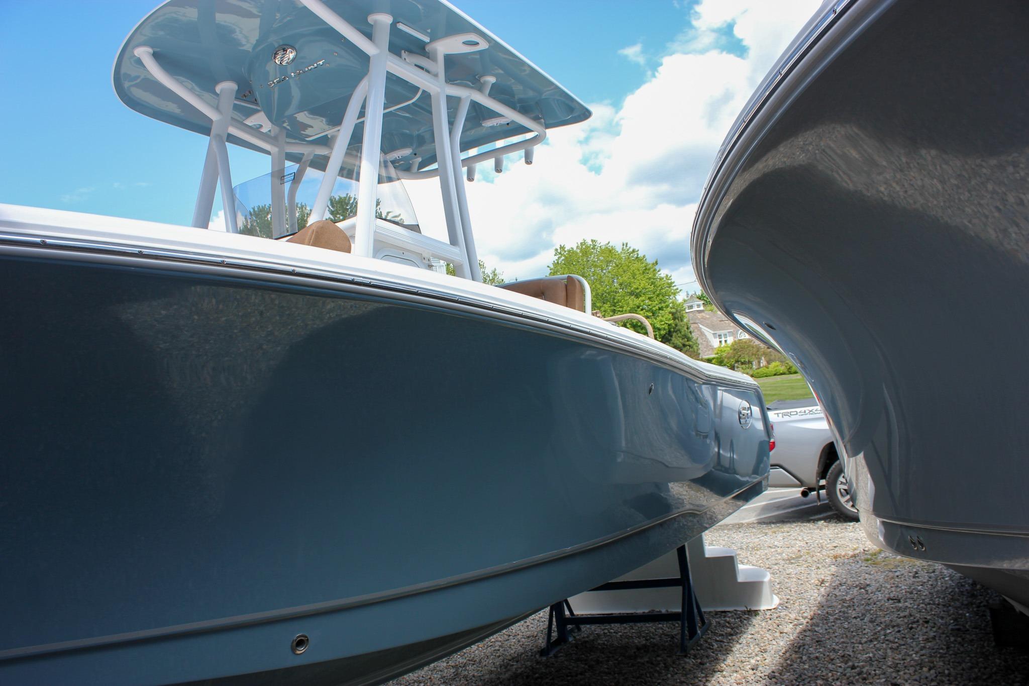 2027 Sea Hunt Ultra 234 boat with sleek blue hull, parked outdoors under a clear sky.