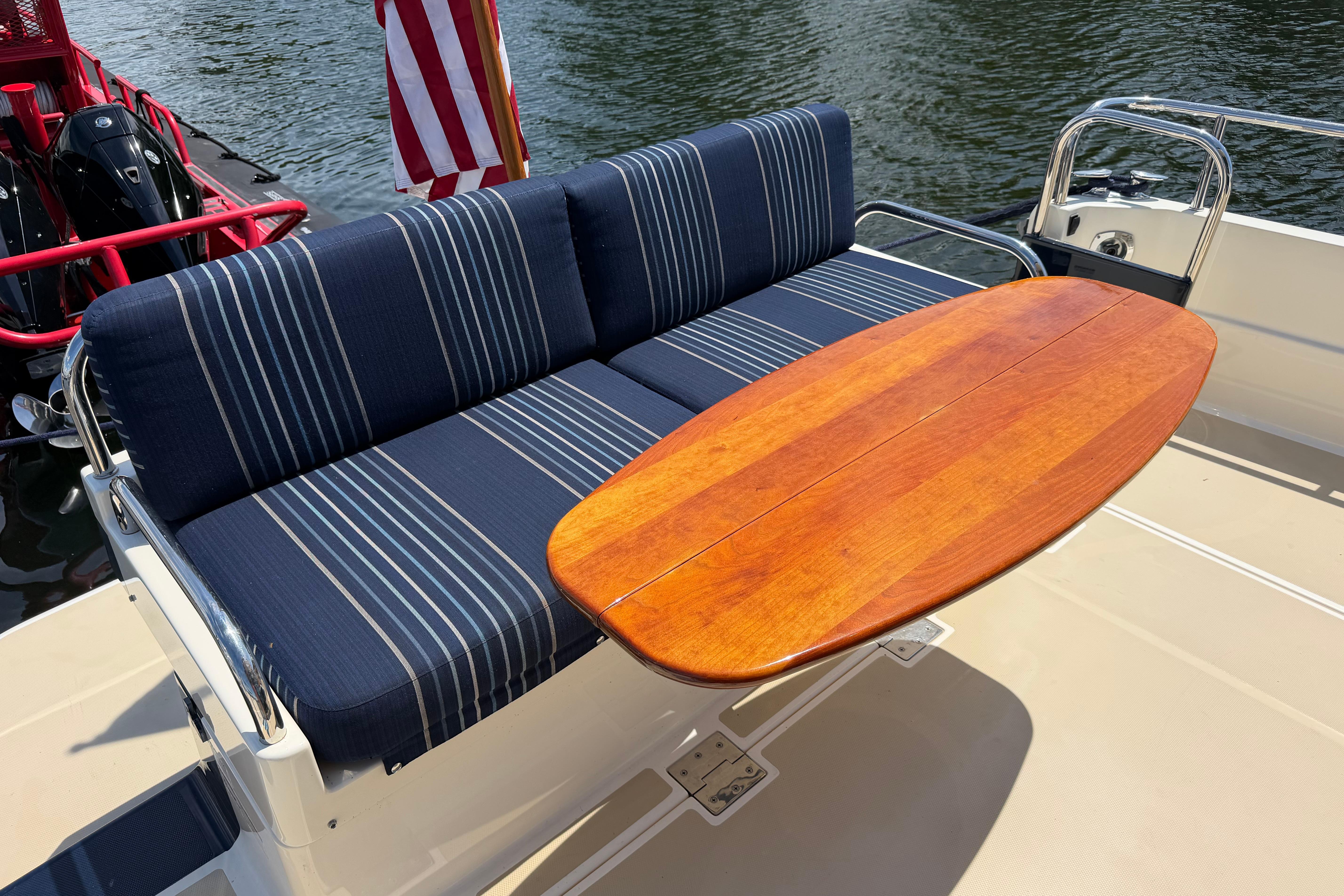 2015 Sabre 38 Salon Express boat with striped seating and wooden table on deck.