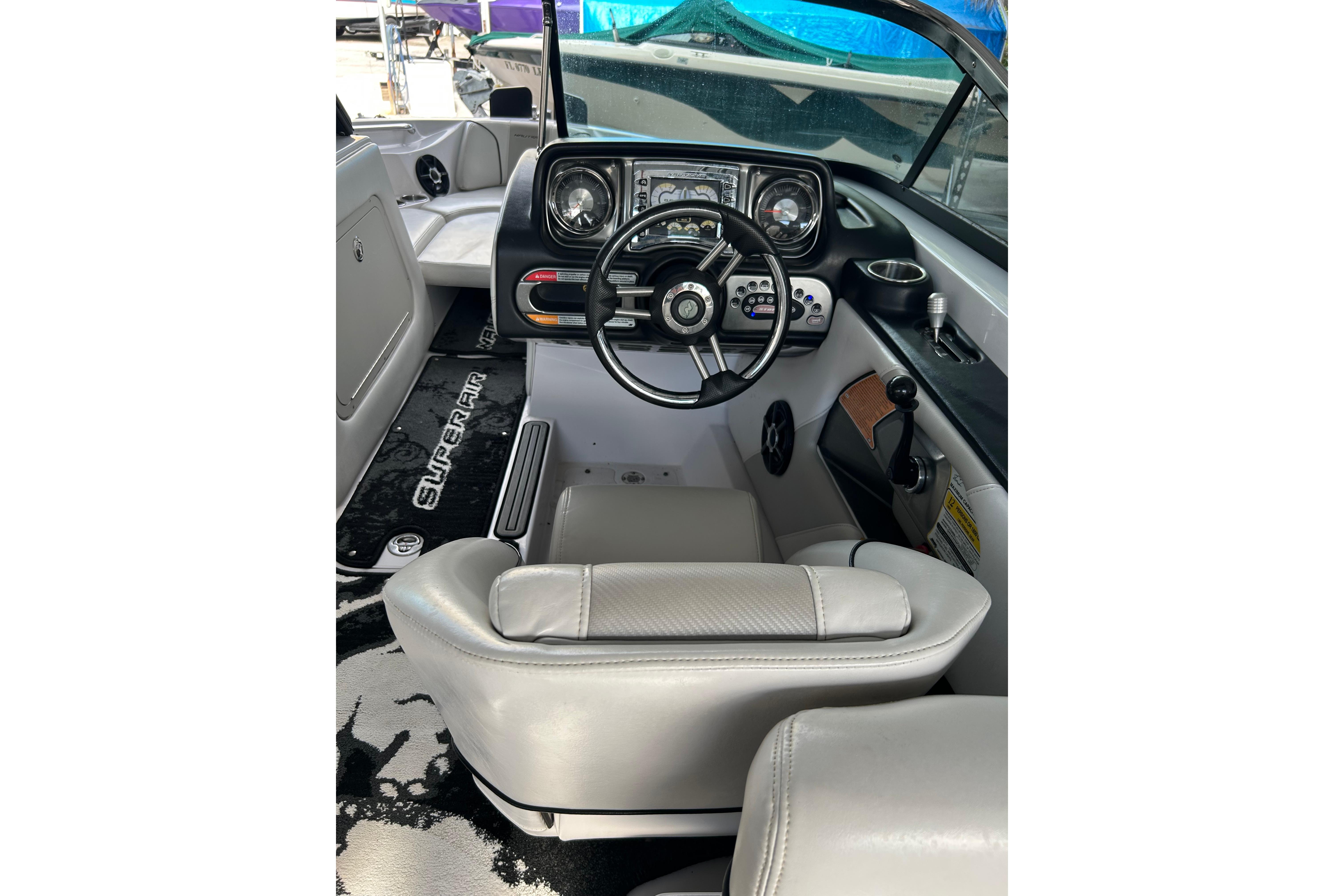 2010 Nautique Super Air Nautique 210 Coastal Edition cockpit with steering wheel and controls.