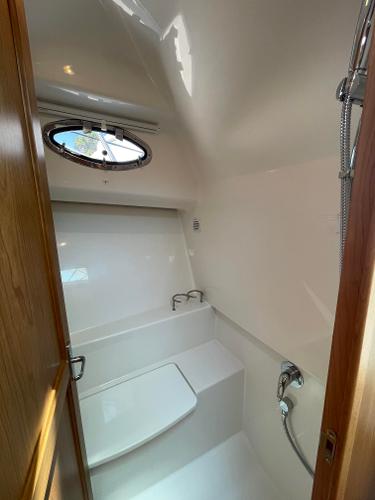 2024 Back Cove 34O boat bathroom with modern fixtures and porthole window.