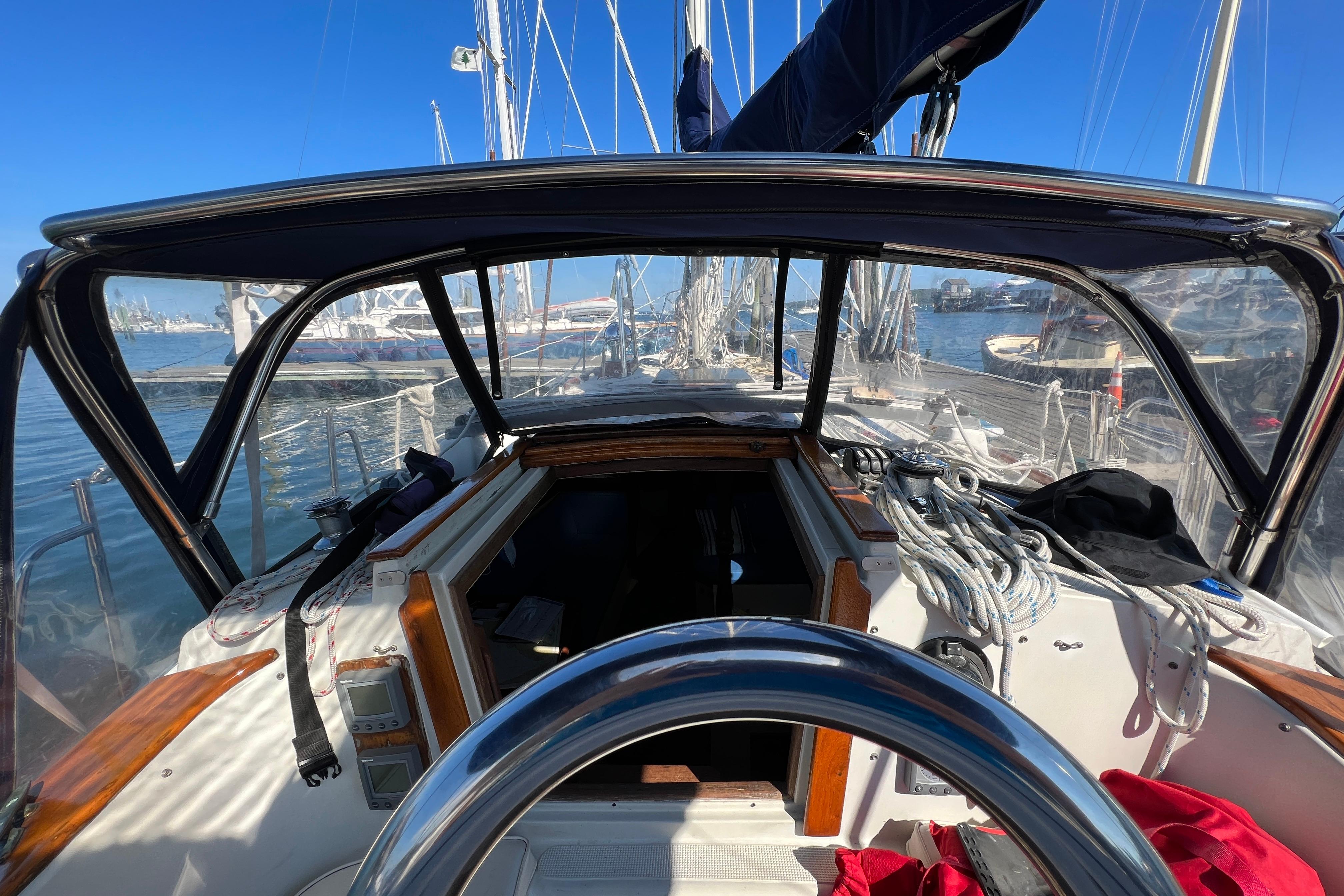 Cockpit view of 1982 Pacific Seacraft 37 sailboat, docked with clear blue sky.