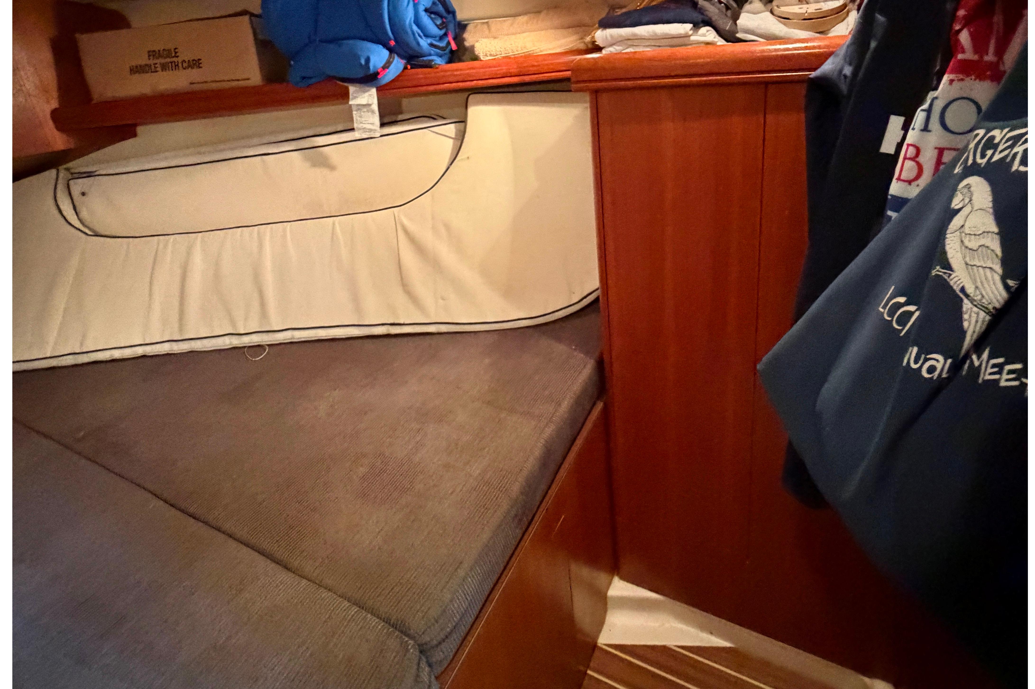 Cozy cabin interior of a 2005 Hunter 38 sailboat with storage and bedding.