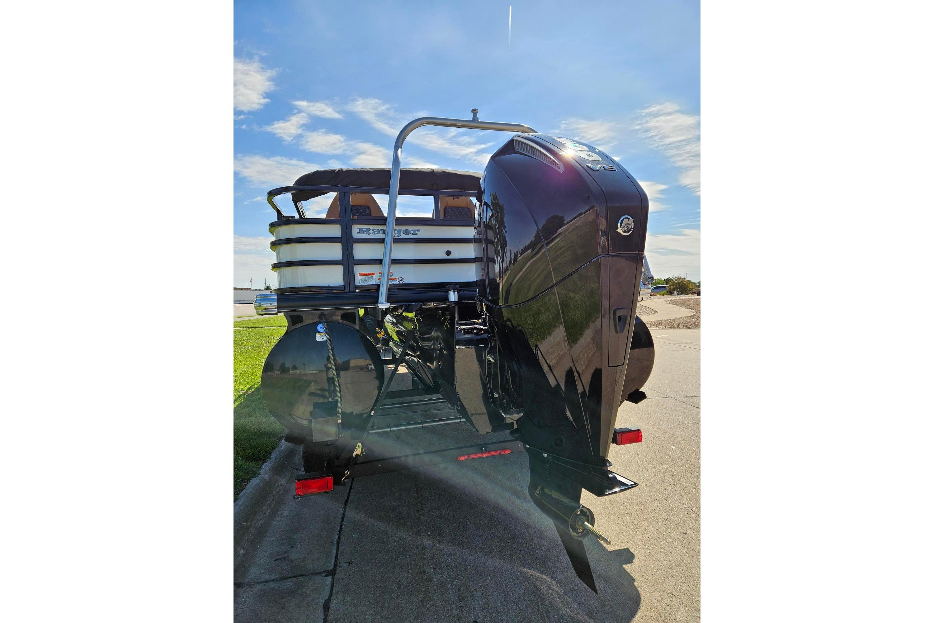 2026 Ranger 223F boat with powerful outboard motor, parked on a sunny day.