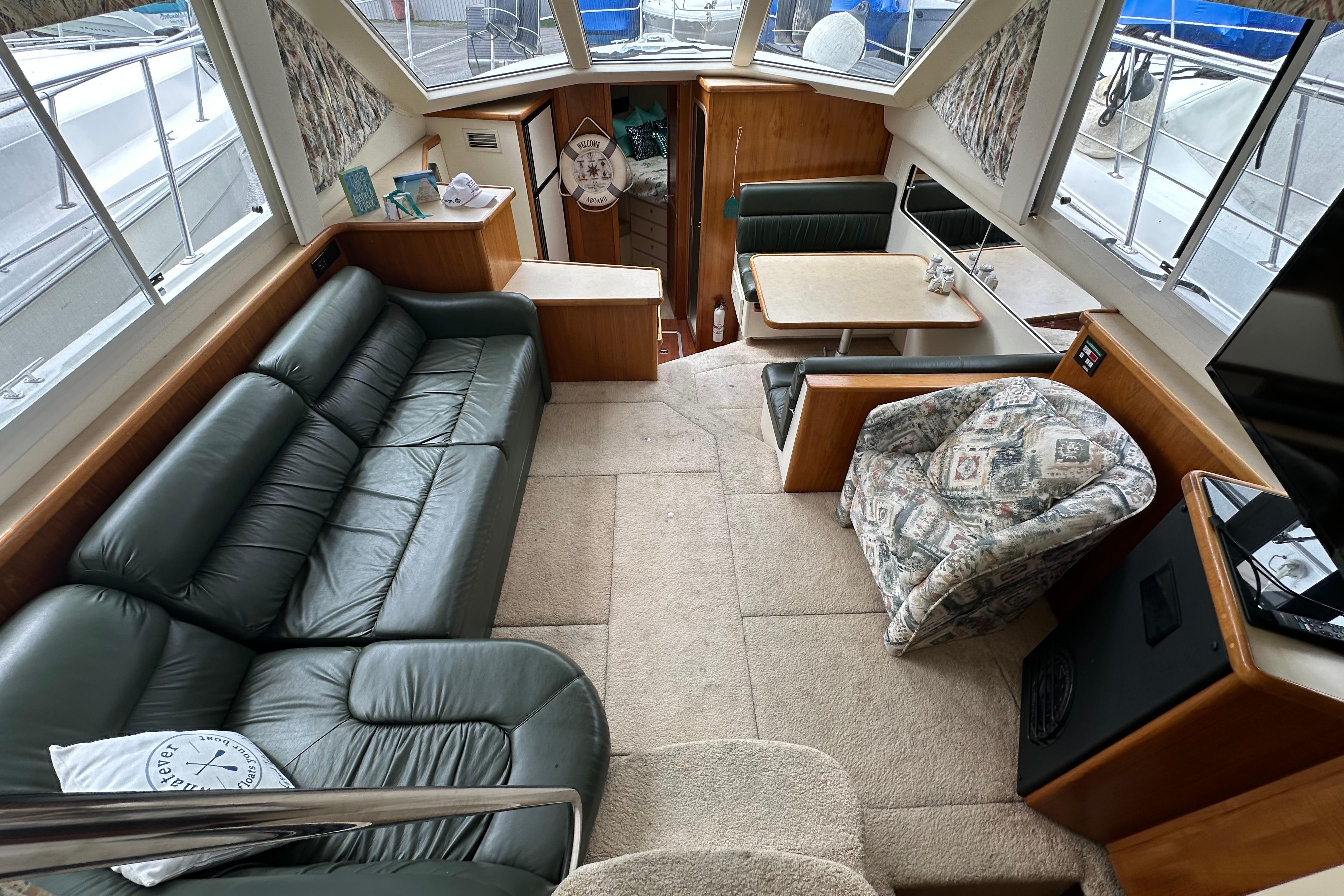 Interior of 1998 Carver 355 Aft Cabin Motor Yacht with leather sofa and dining area.