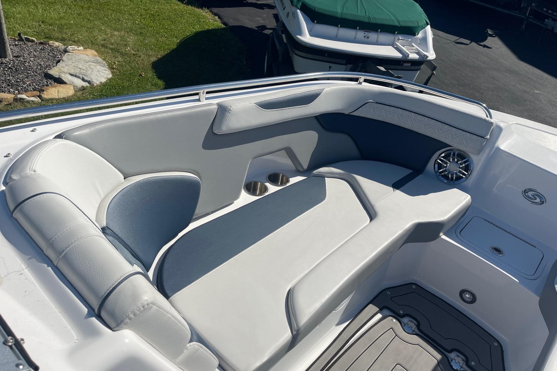 2023 Hurricane SunDeck 2400 OB boat interior with cushioned seating and cup holders.