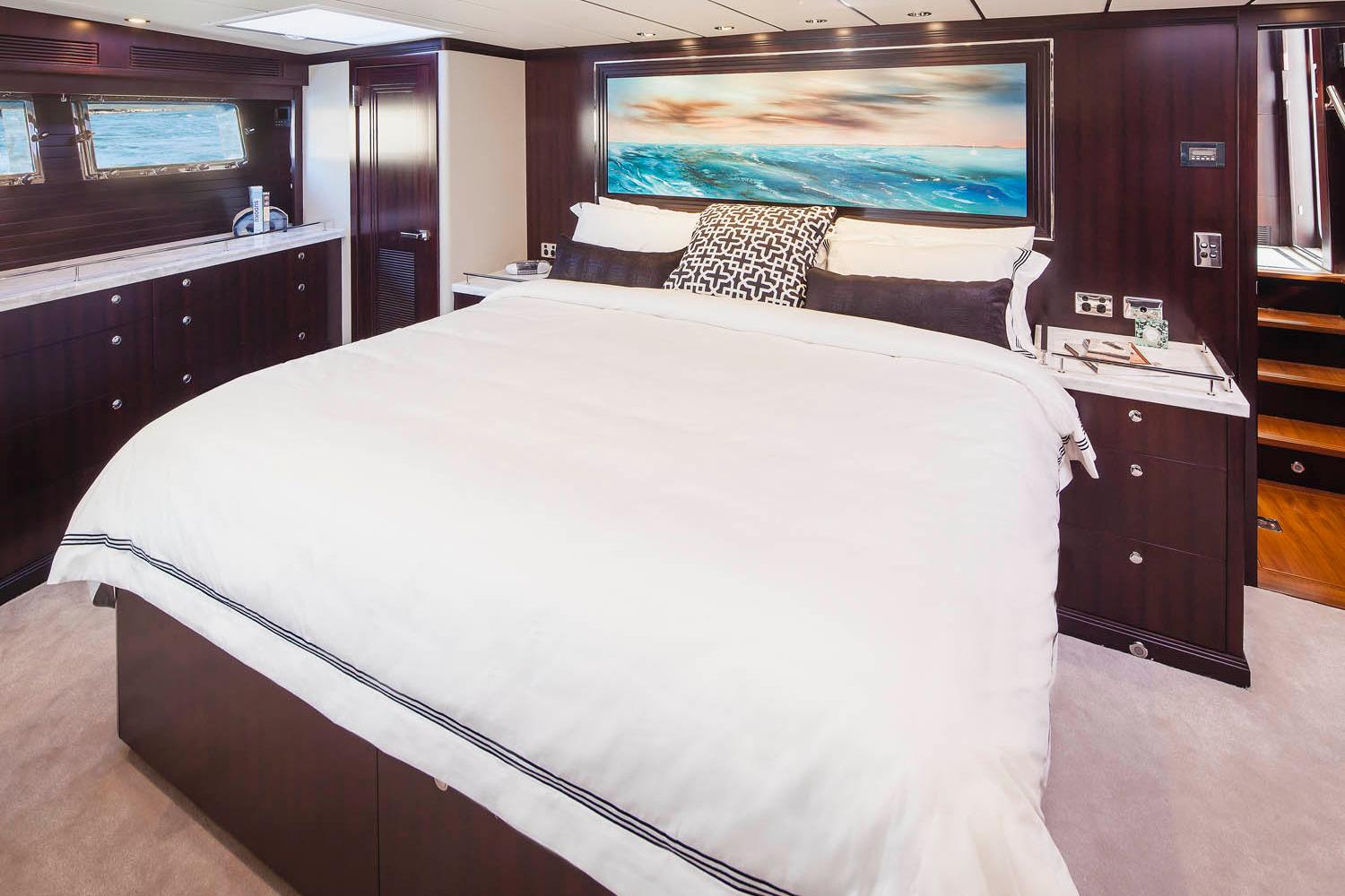 Luxurious bedroom interior of 2027 Nordhavn 68 yacht with elegant bedding and ocean view.