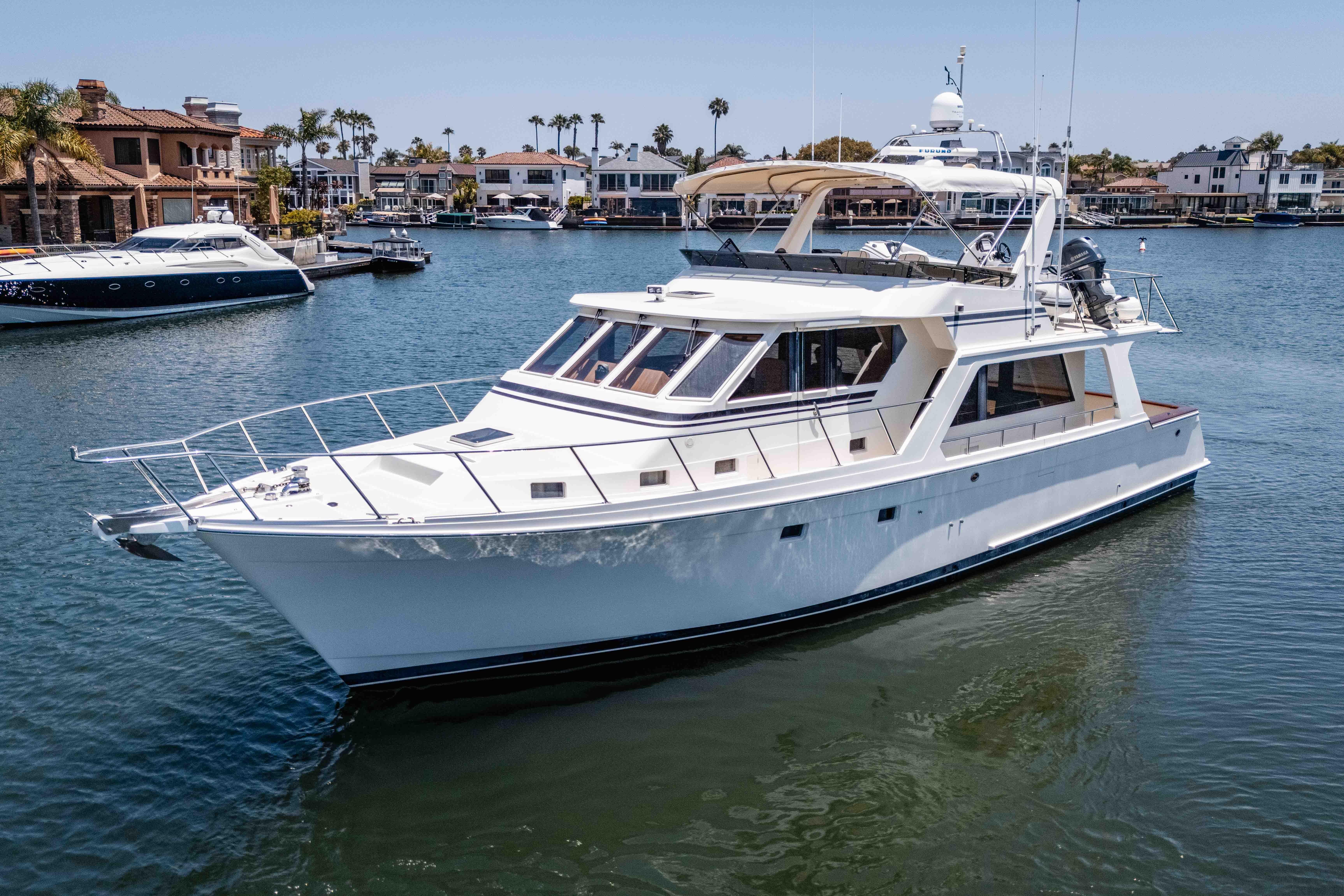 2005 Offshore Yachts 54 Pilothouse cruising in a scenic marina setting.