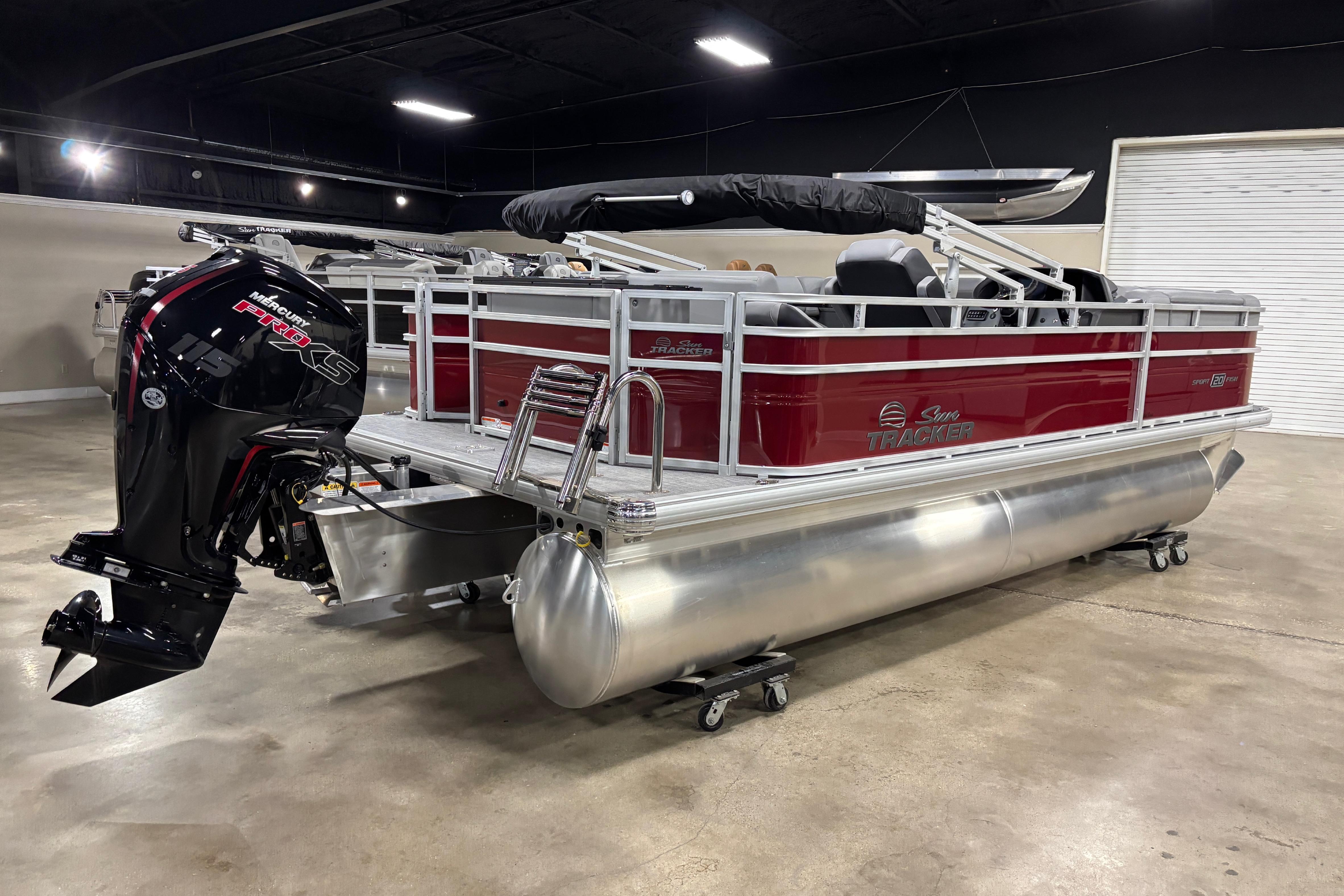 2026 Sun Tracker SportFish 20 DLX pontoon boat with Mercury engine in showroom.