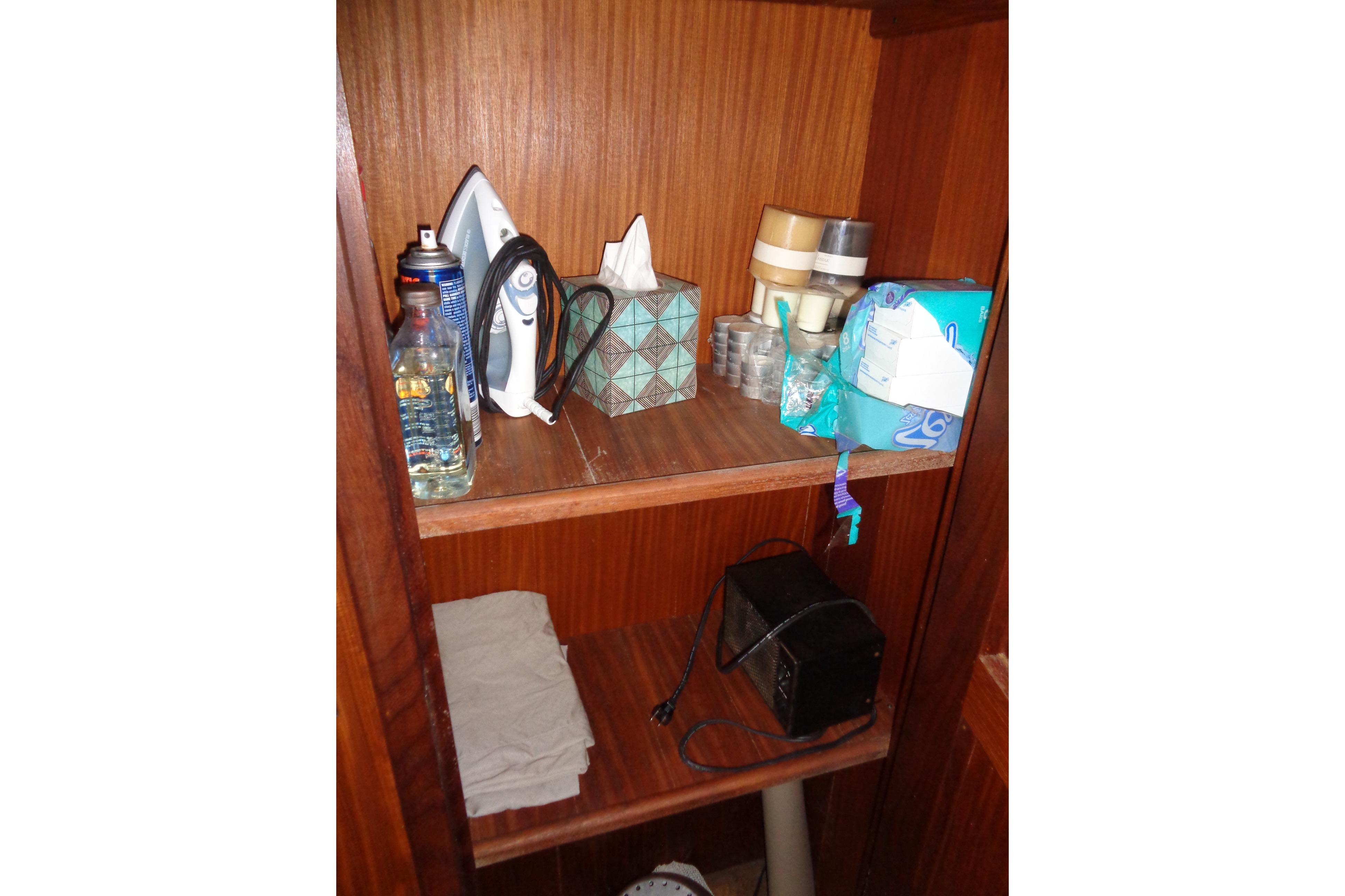 Storage shelf on 1981 Hatteras 48 Cockpit Motor Yacht with household items and supplies.
