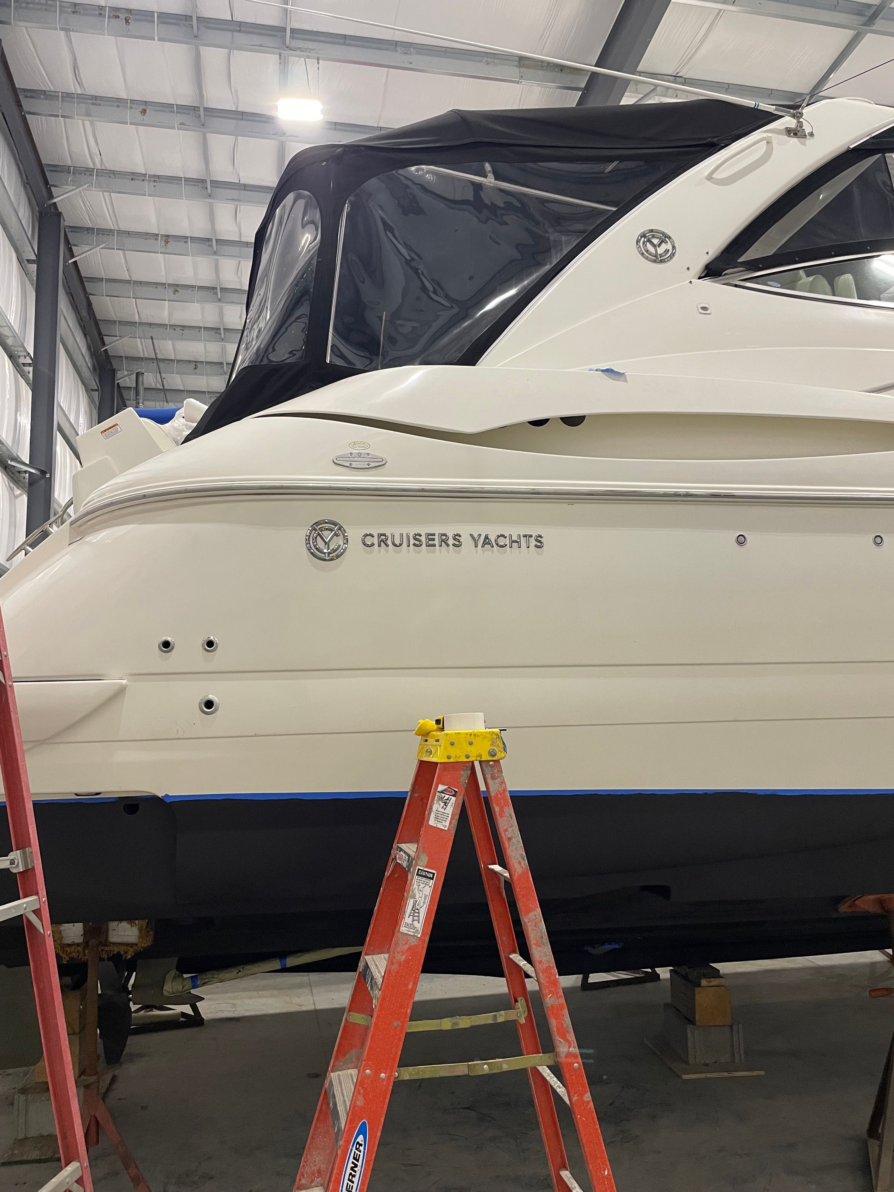 A 2005 Cruisers Yachts 440 Express in a shipyard building.