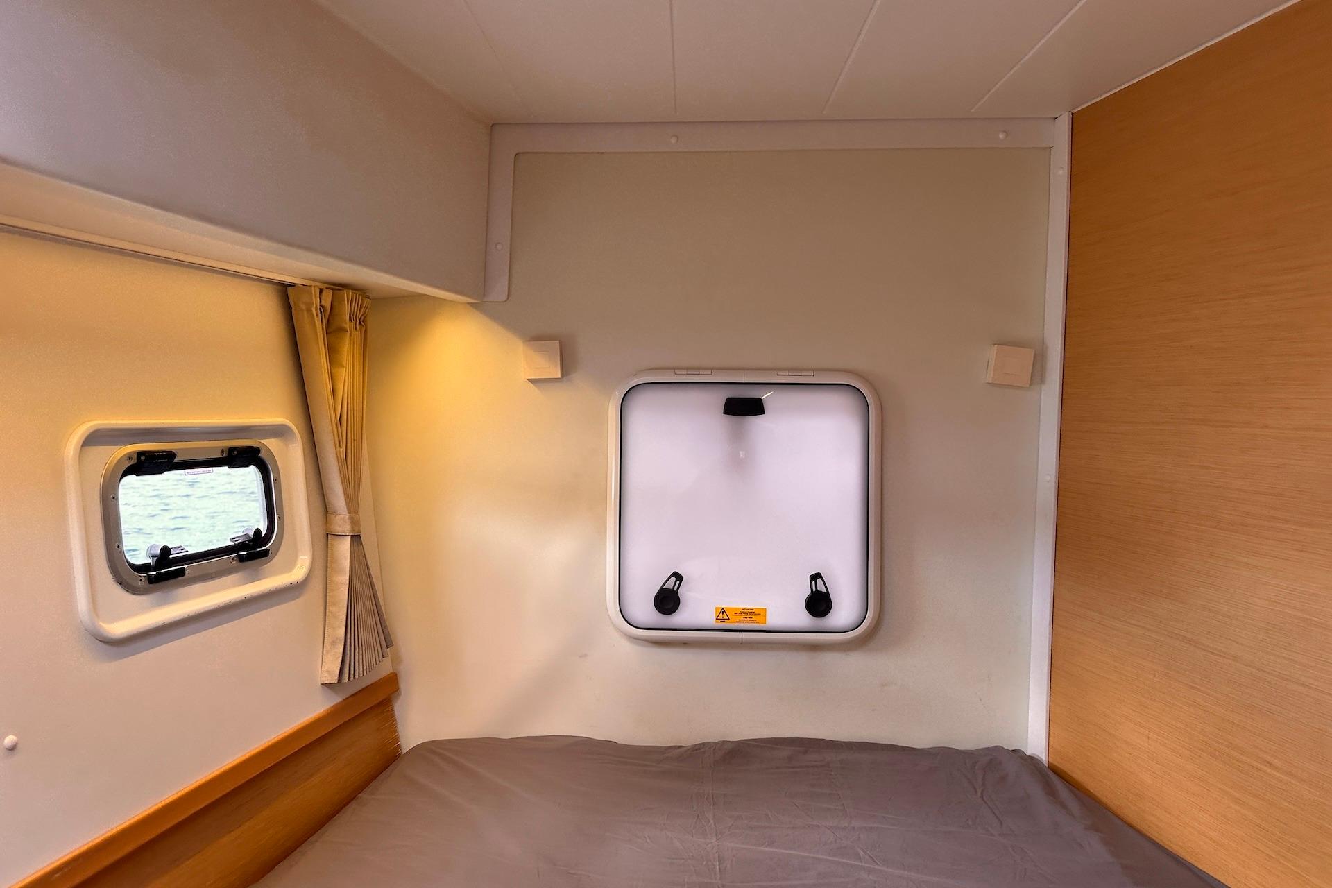 Cozy interior cabin of 2016 Lagoon 42 catamaran with window and bed.