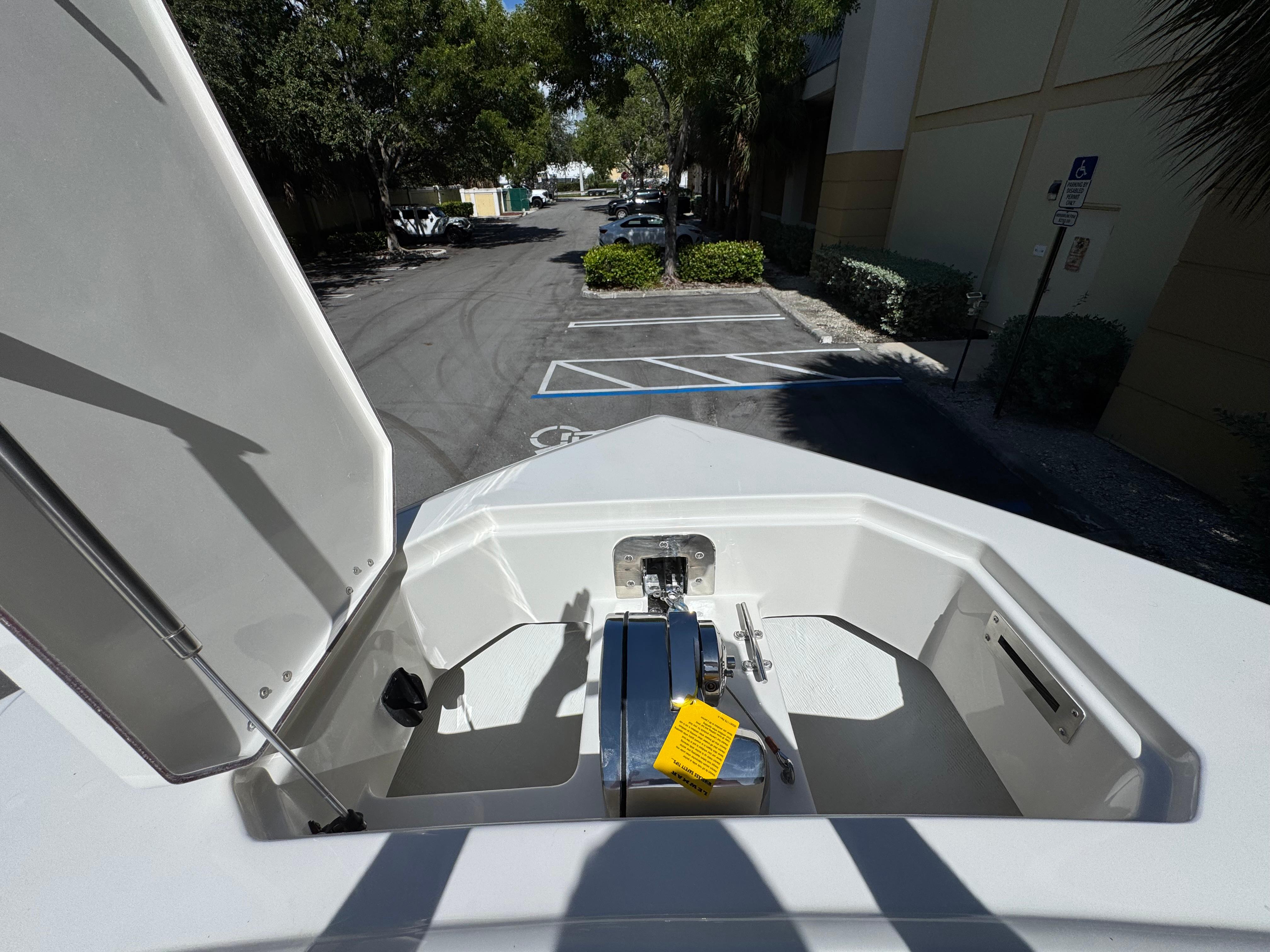 Open anchor compartment of 2026 Sailfish 312 CC boat in a parking lot.