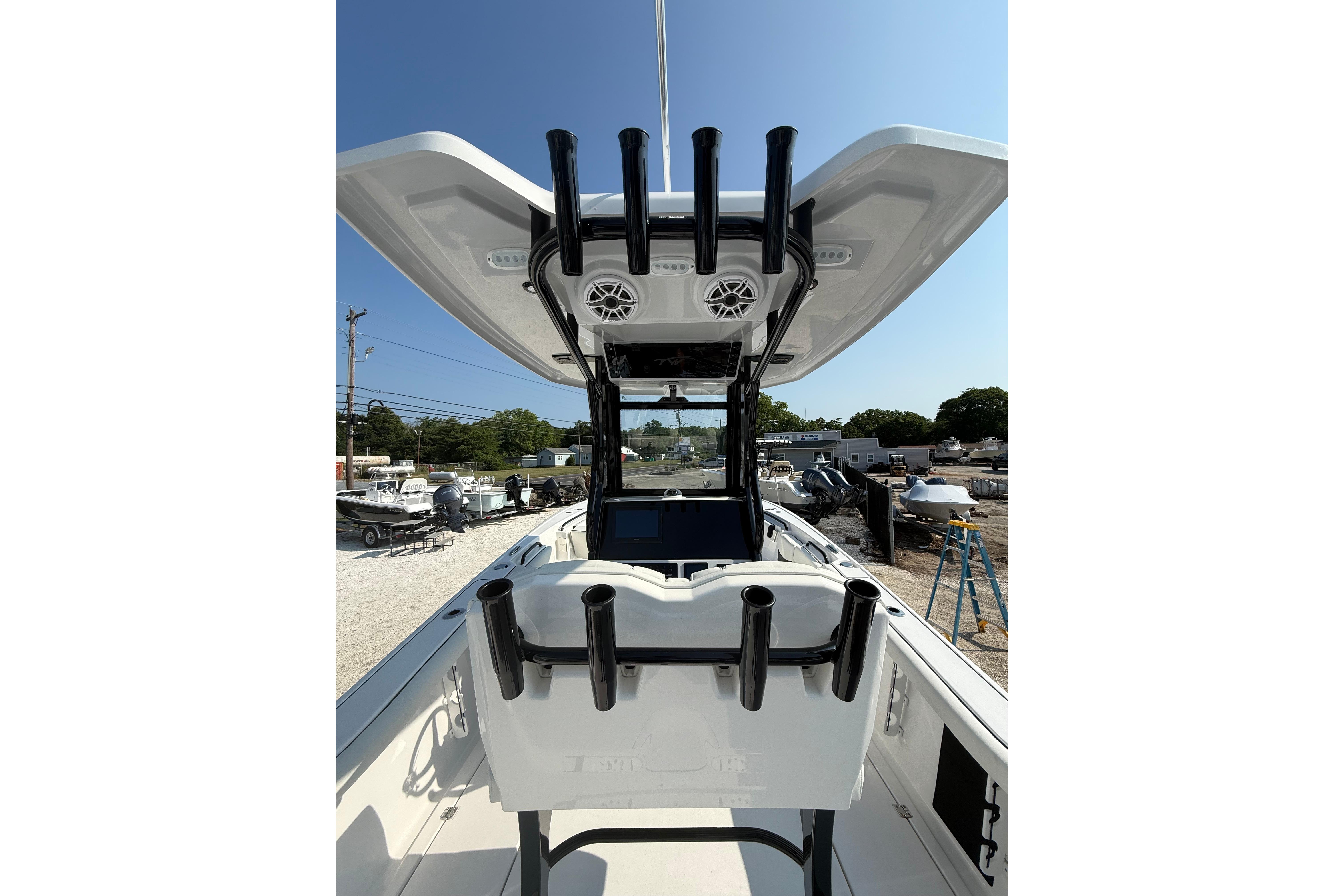 2026 Tidewater 256 CC Adventure boat with rod holders and T-top in a marina setting.