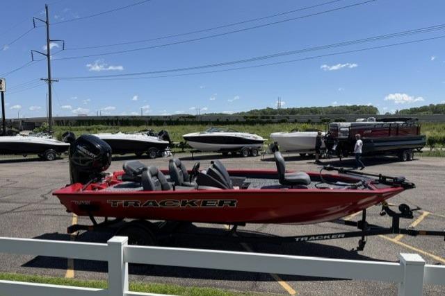 2026 Tracker Pro Team 175 boat in a parking lot, vibrant red color, sunny day.