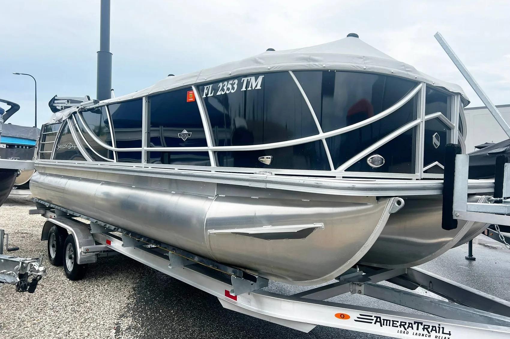 2023 South Bay 523 R pontoon boat on trailer, sleek design, silver and black finish.