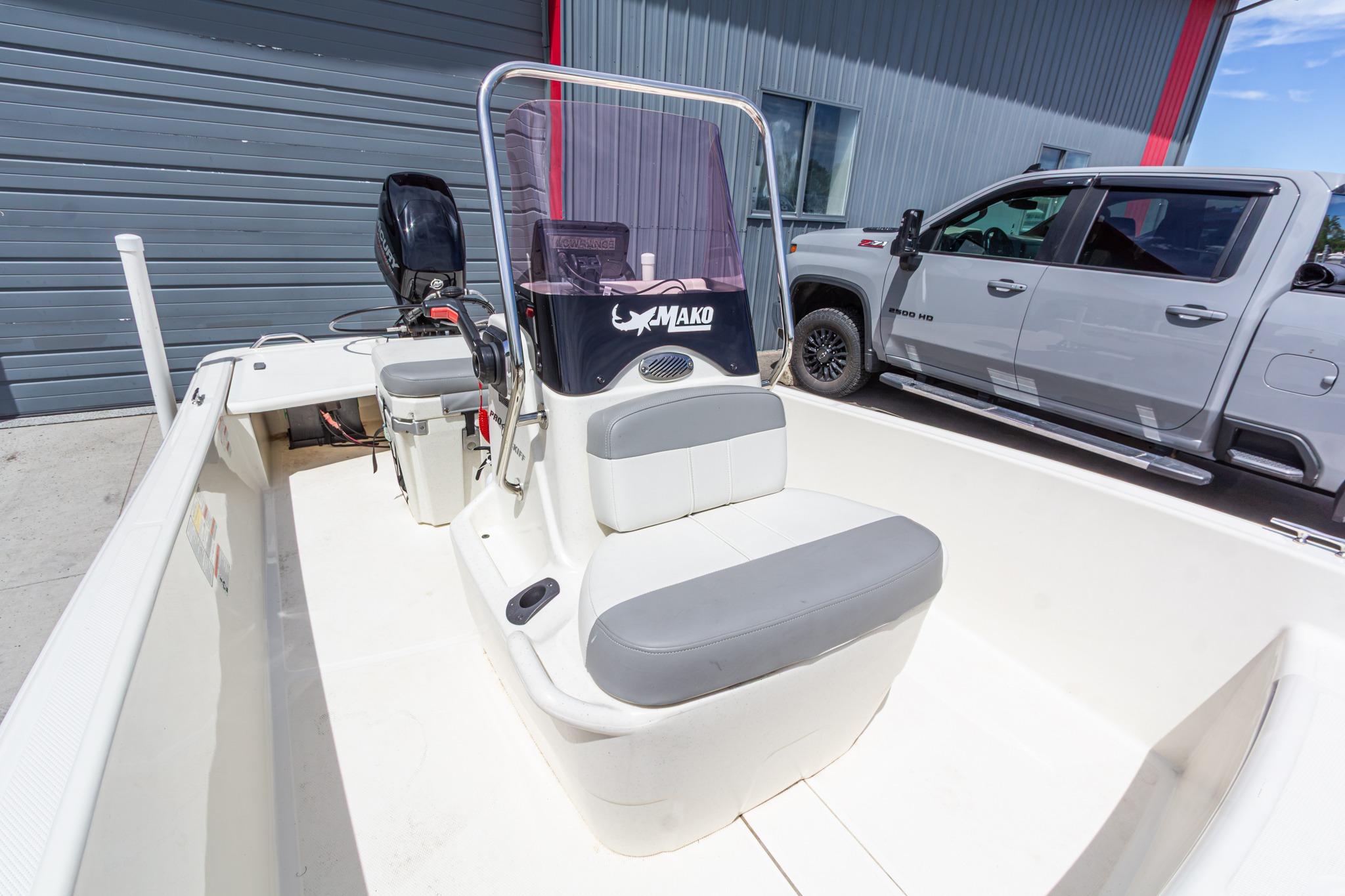 2020 Mako Pro Skiff 15 CC boat with center console, parked beside a gray truck.