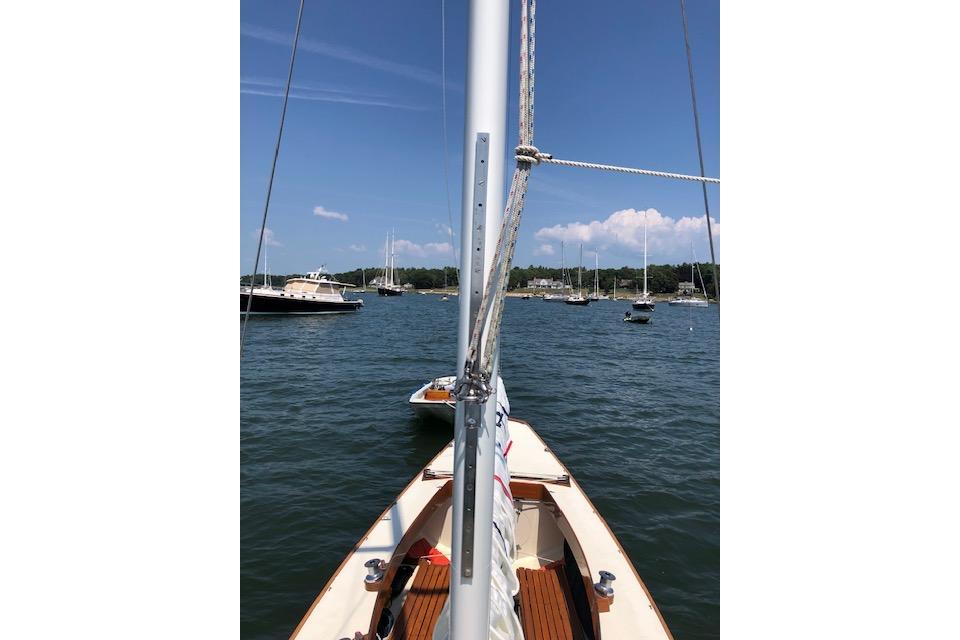 Sailboat on calm waters, Cape Cod Shipbuilding Shields model, 1963, with scenic harbor view.