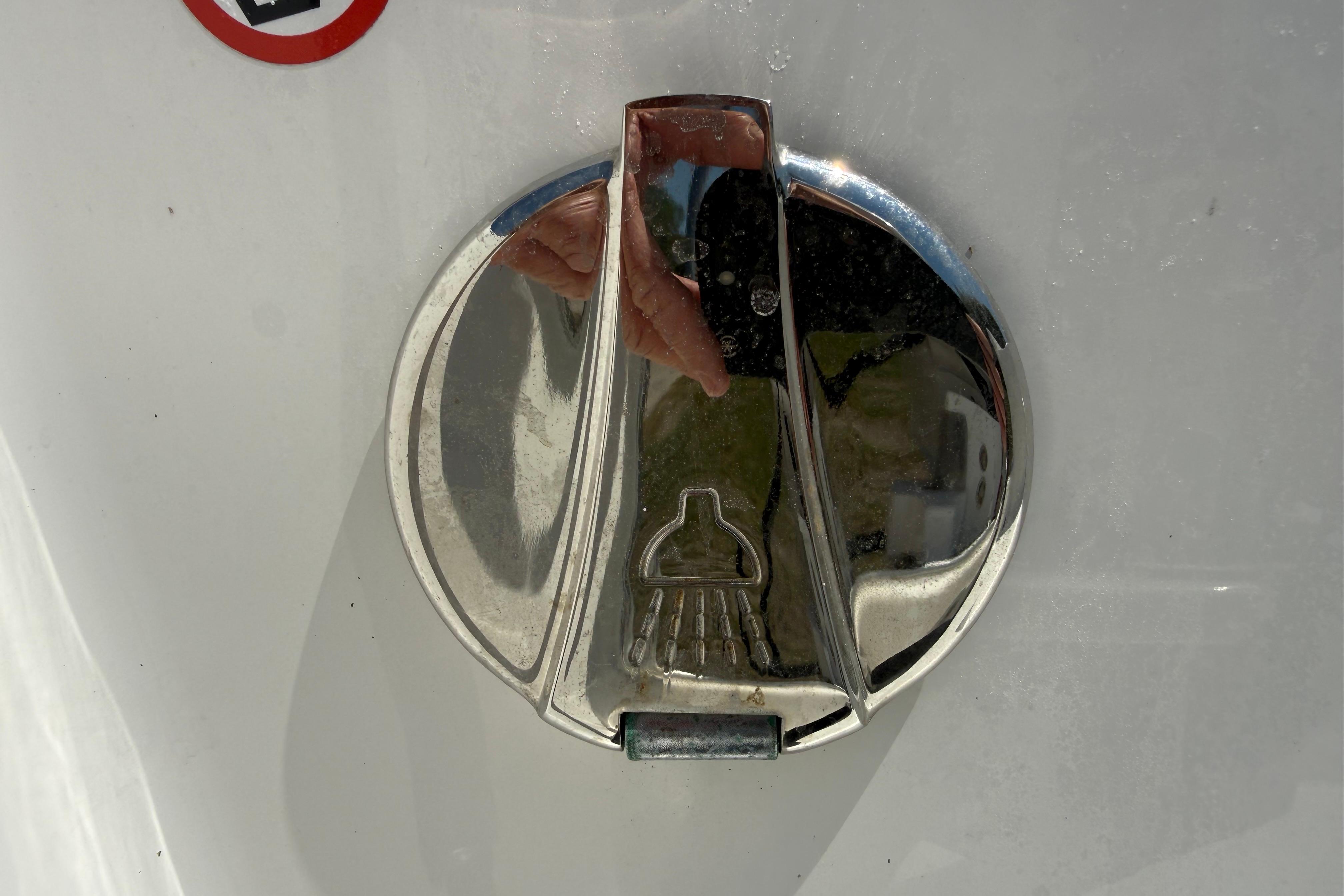 Chrome fuel cap on 2023 Regulator 26XO boat, reflecting surroundings.