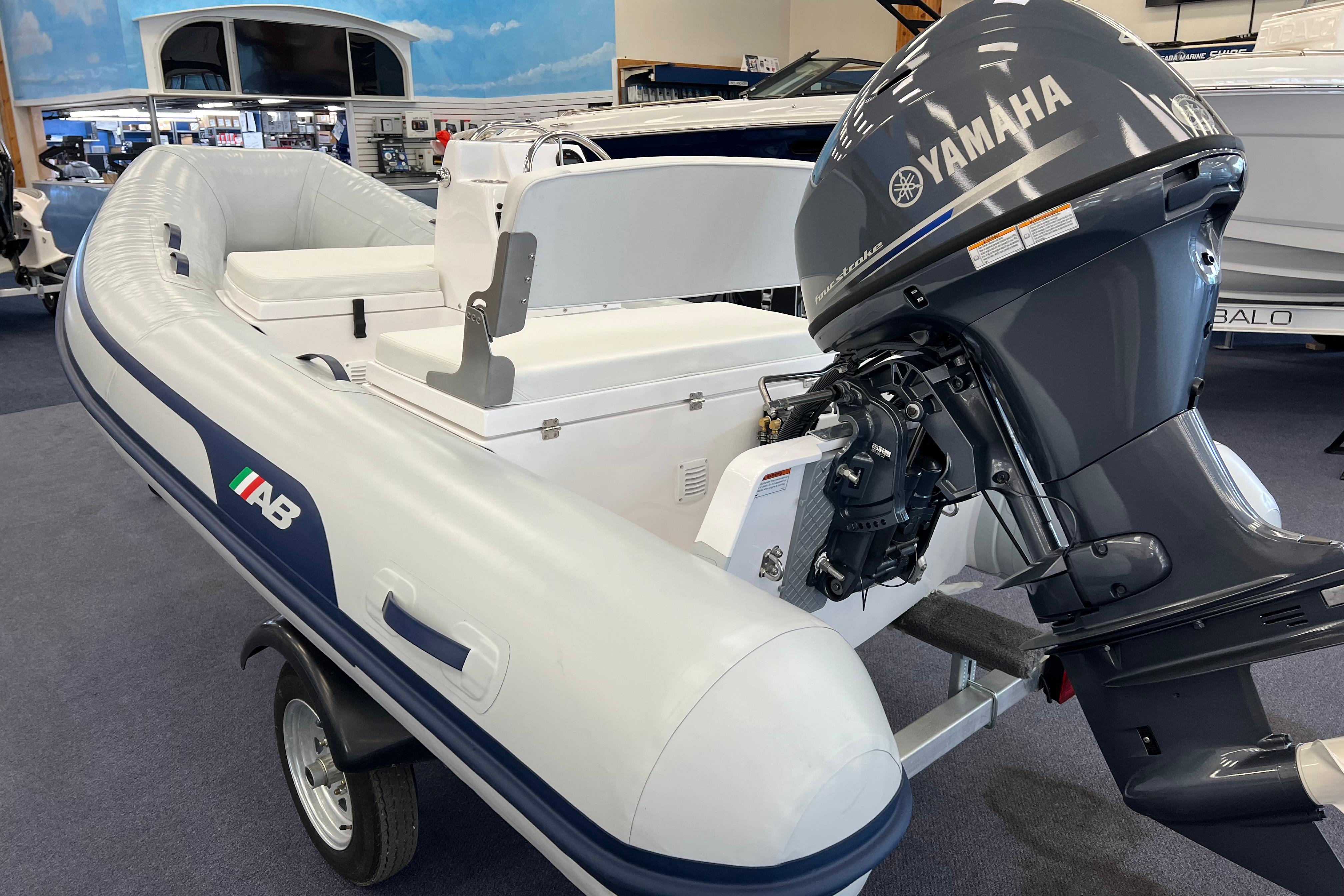 2023 AB Inflatables Mares 12 VSX boat with Yamaha outboard motor displayed indoors.