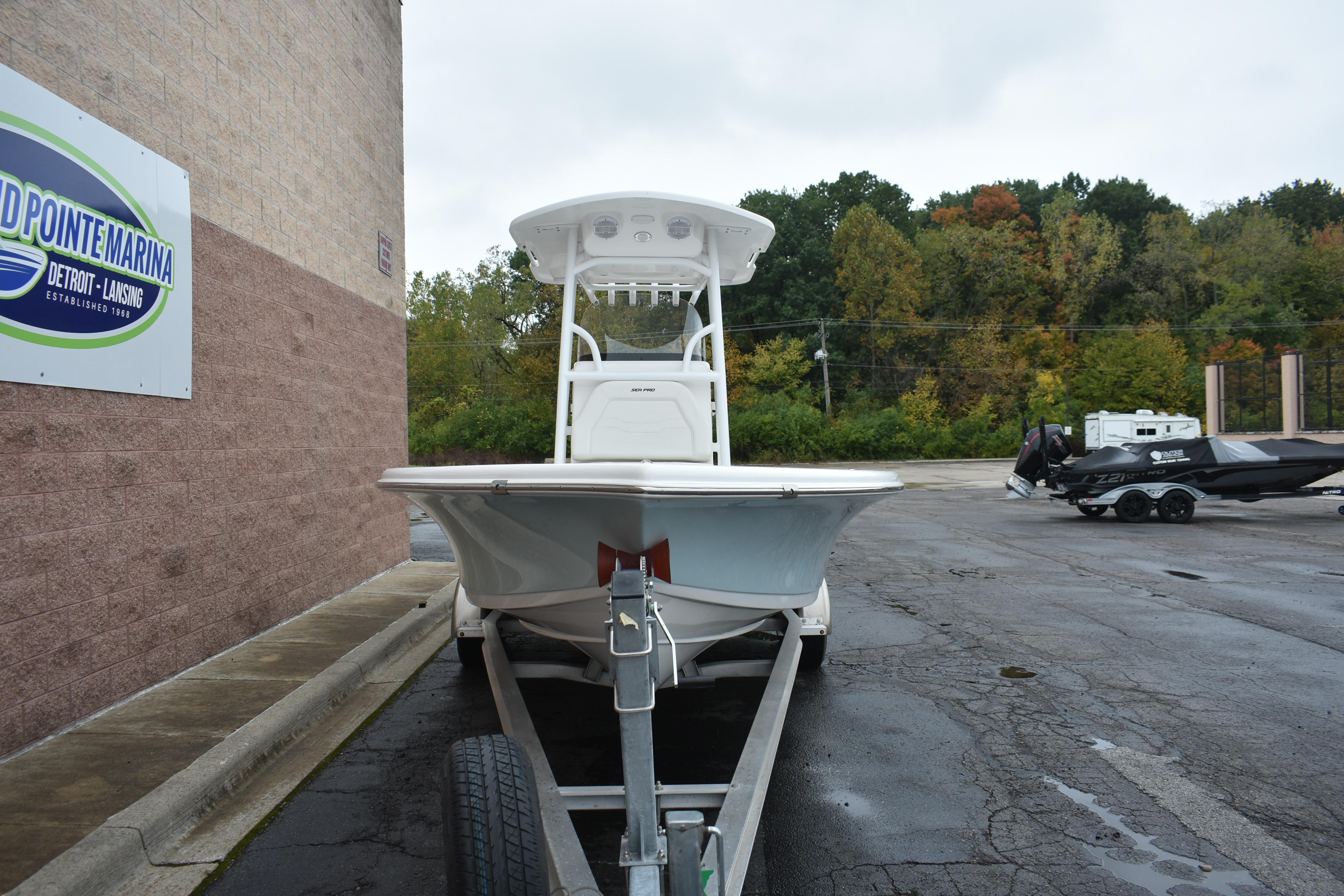 2025 Sea Pro 250 Bay boat on trailer at marina parking lot.