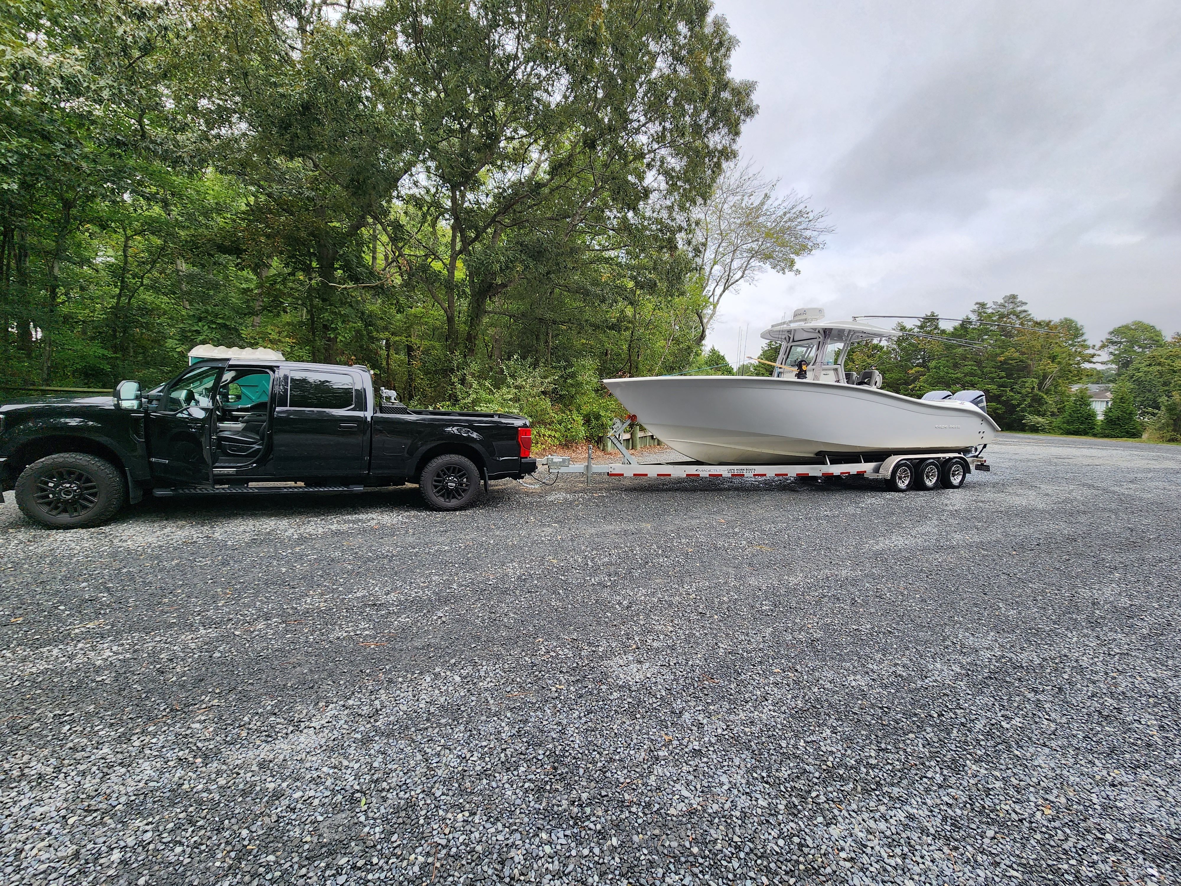 Black truck towing 2021 Cape Horn 32 XS boat on trailer.