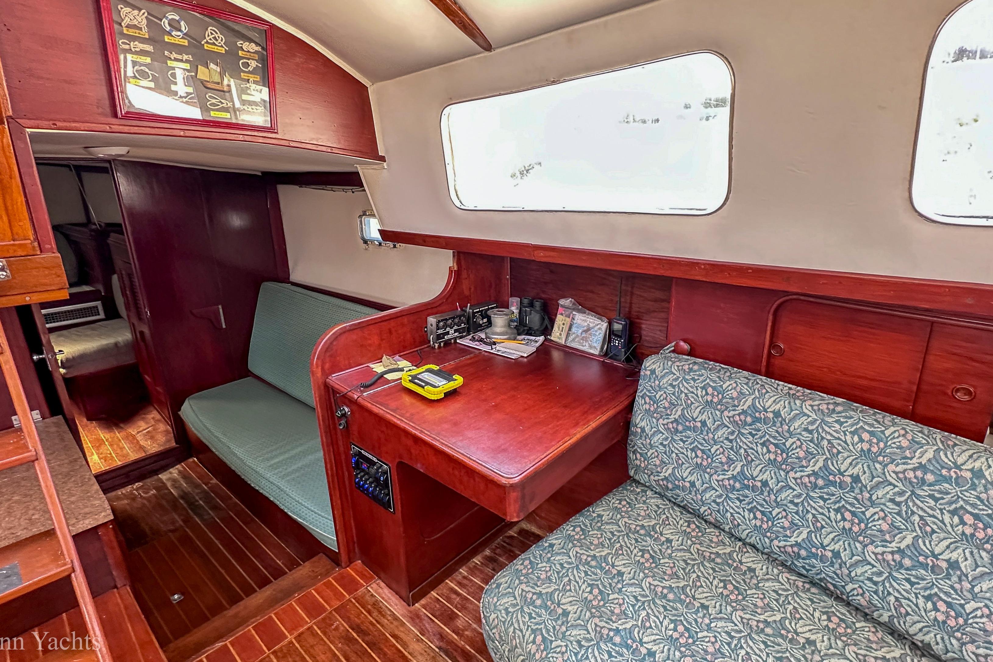 Interior of a 1980 Irwin 46 yacht with wooden furnishings and seating area.