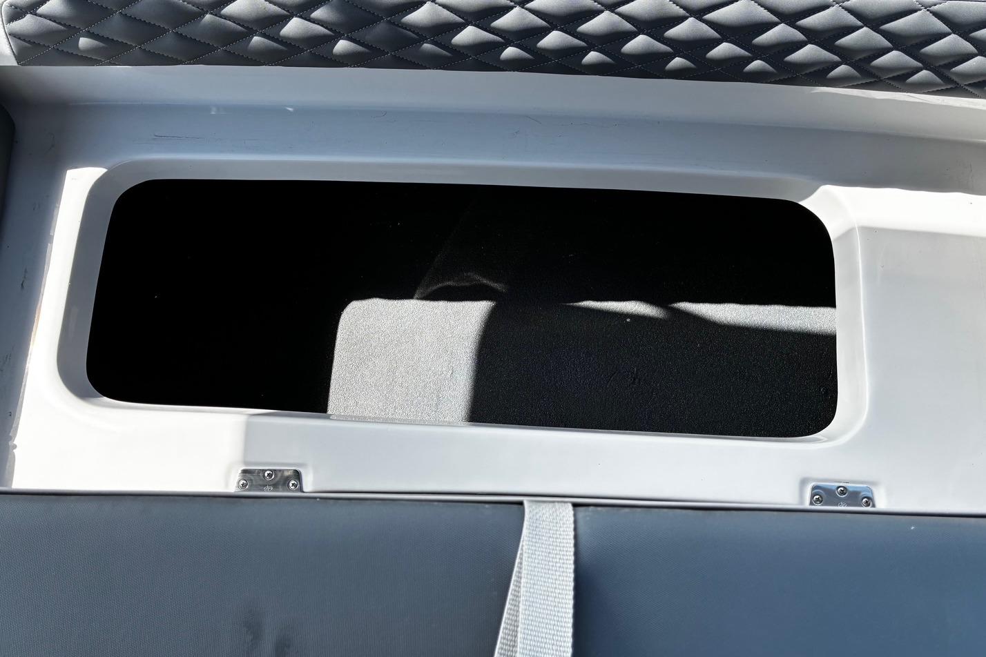 Storage compartment in 2026 Starcraft SVX 191 OB boat with quilted upholstery.
