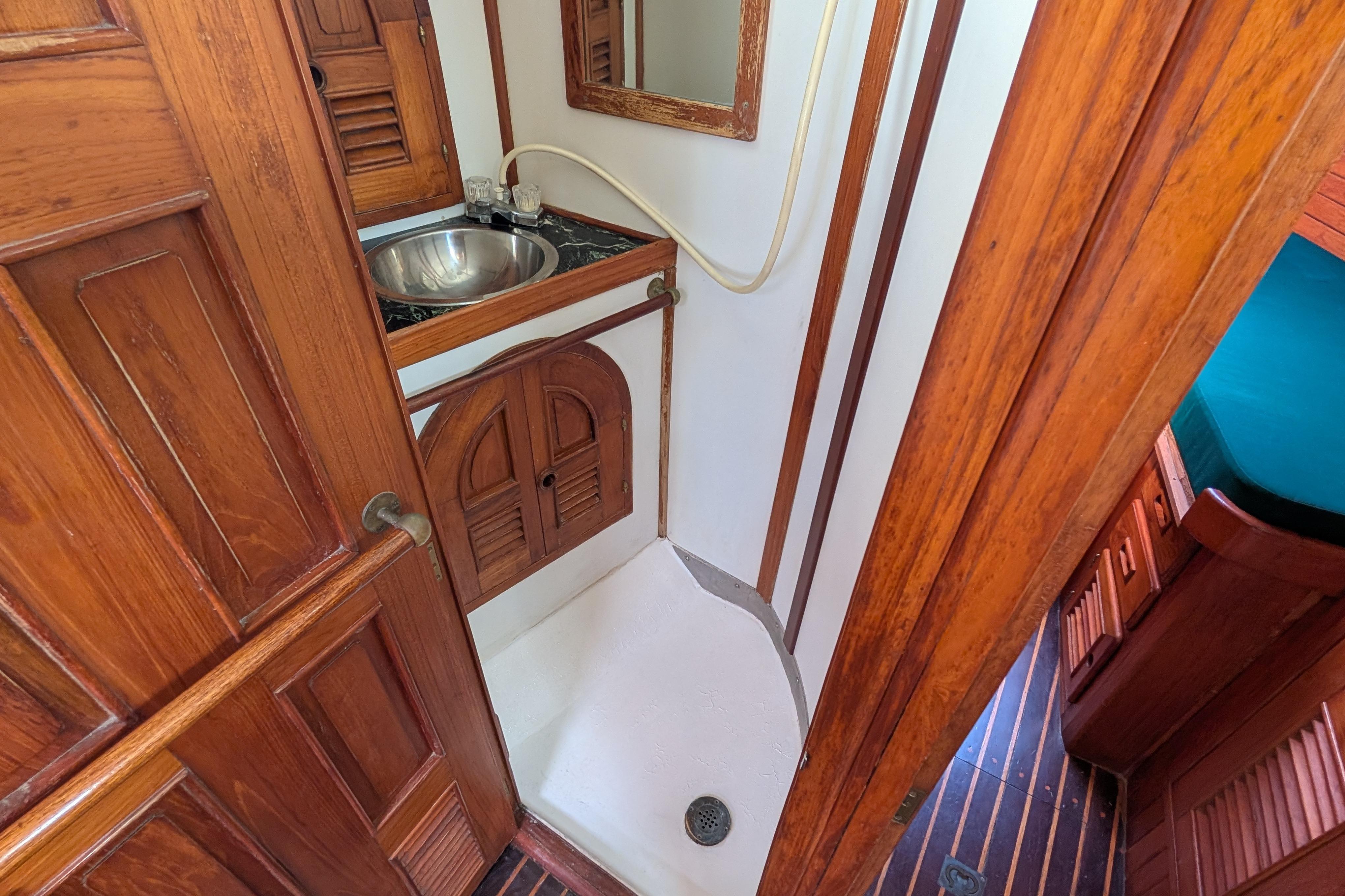1983 Perry 41 yacht bathroom with wooden cabinetry and compact shower area.