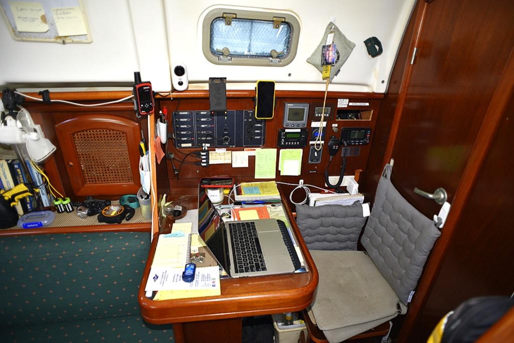 Navigation station inside 1999 Beneteau 36 Oceanis CC sailboat with laptop and equipment.