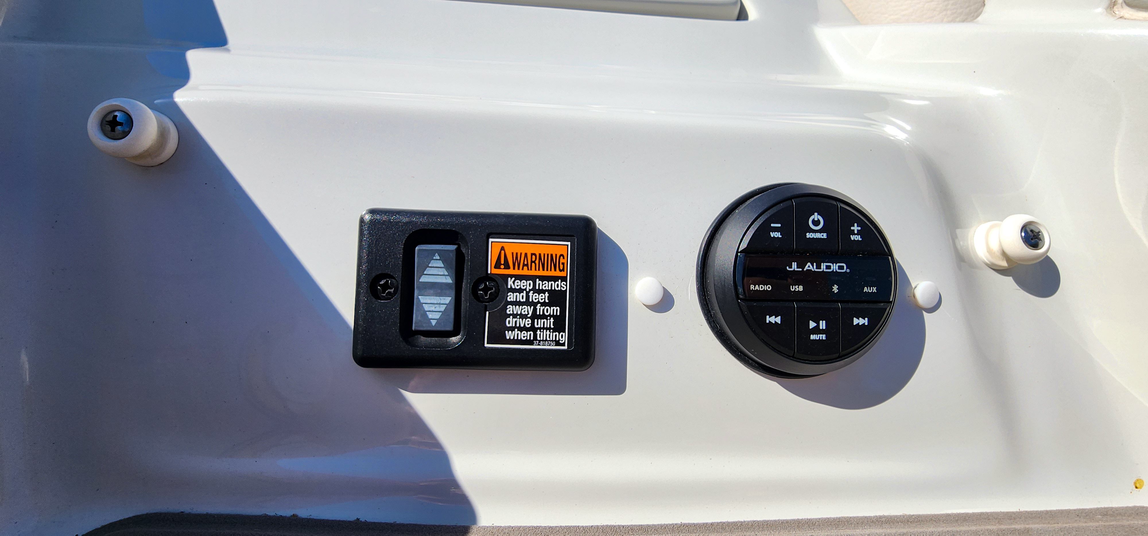 Close-up of a control panel with a warning label and a JL Audio control panel.