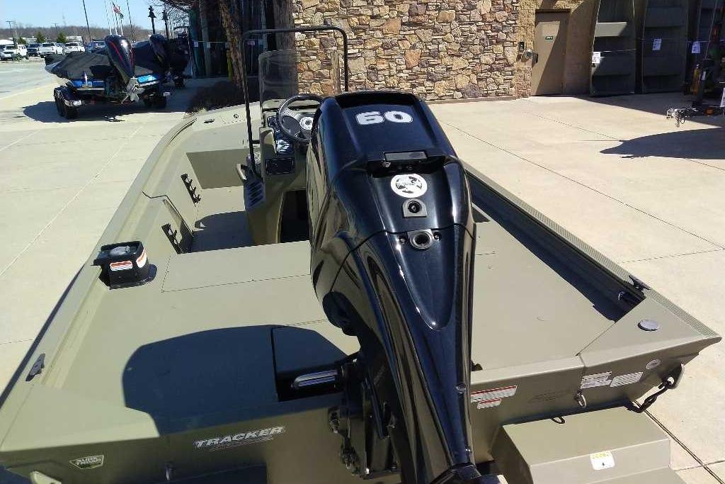 2026 Tracker Grizzly 1860 CC boat with powerful outboard motor, parked outdoors.